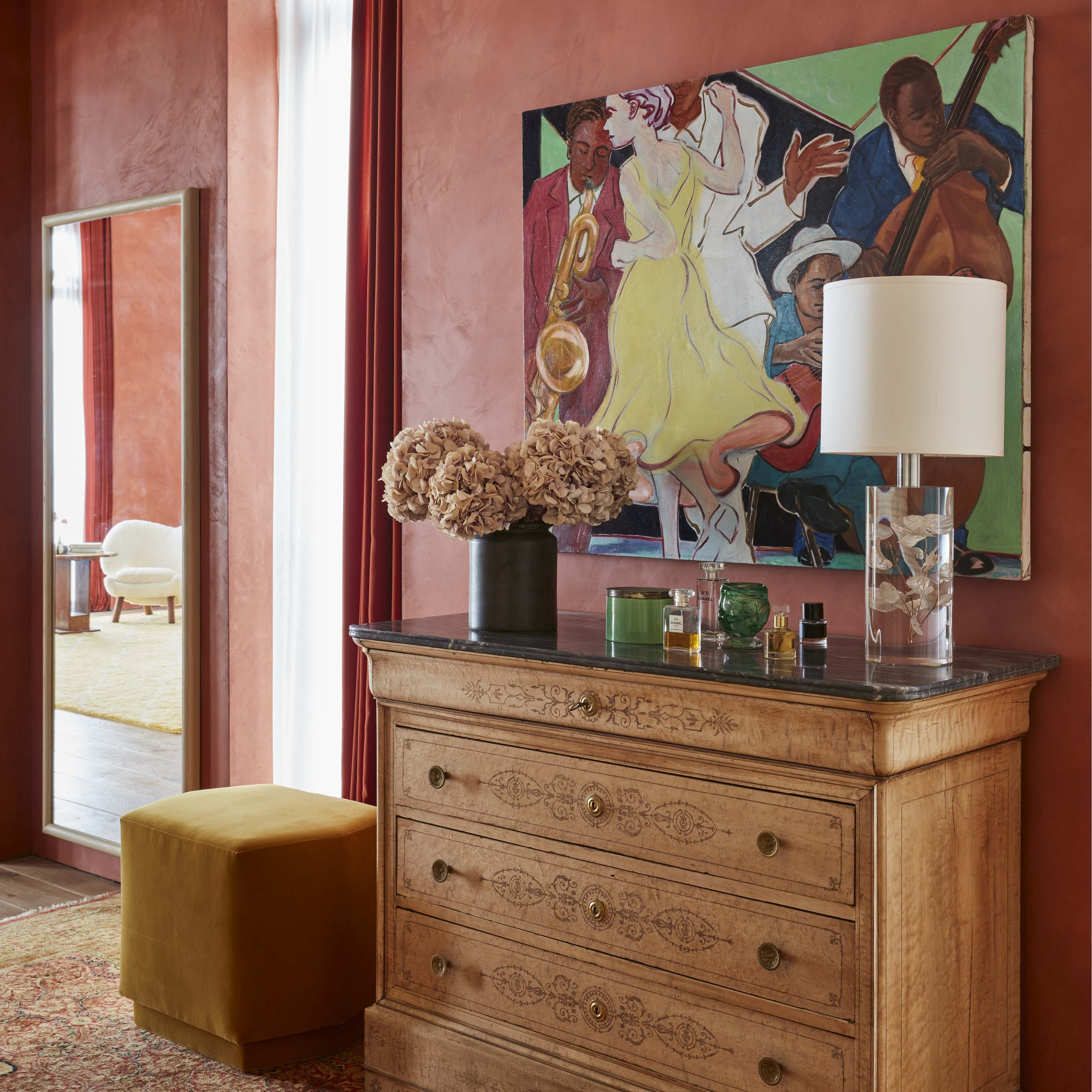 a room with a dresser and a painting on the wall