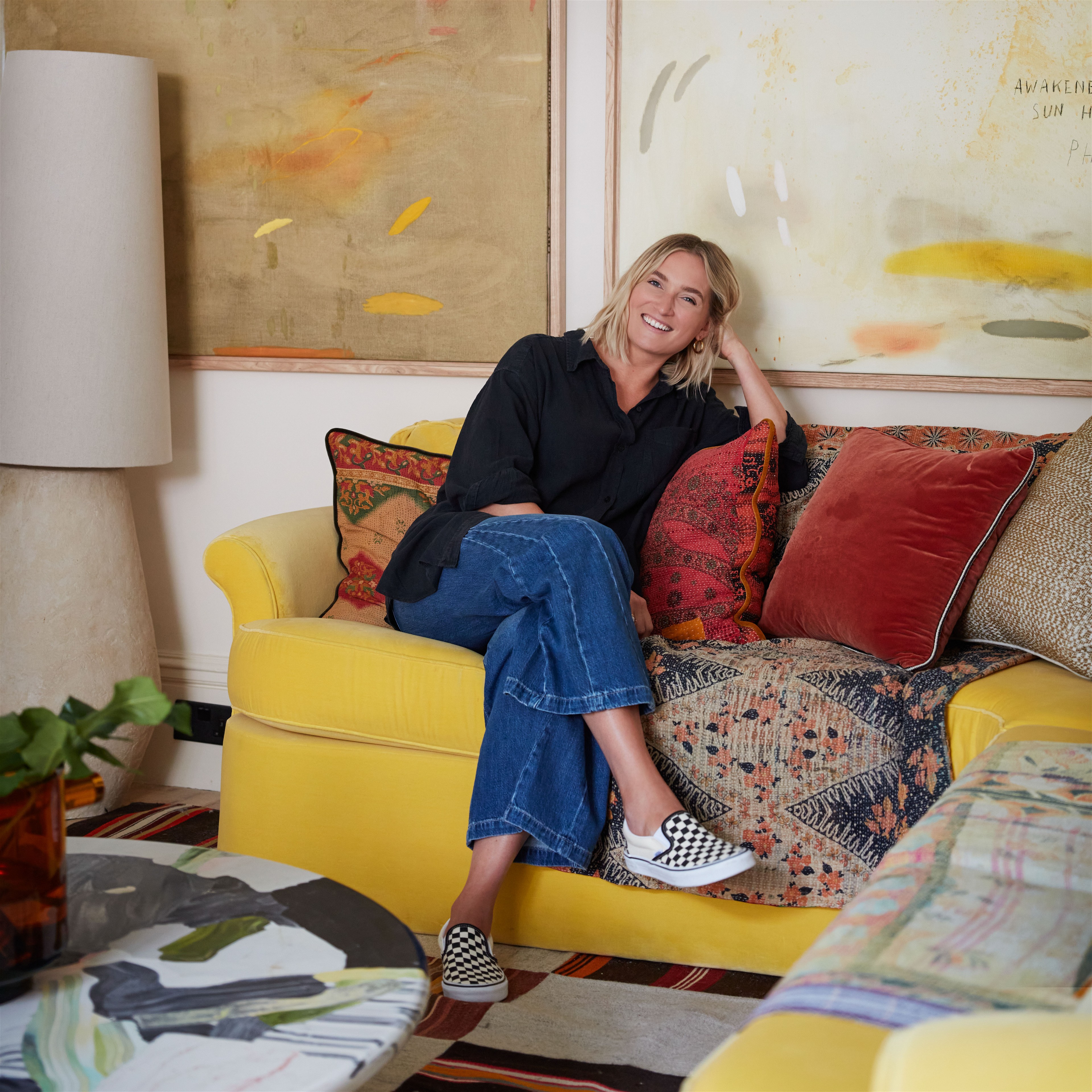 a woman sitting on a yellow couch in a living room