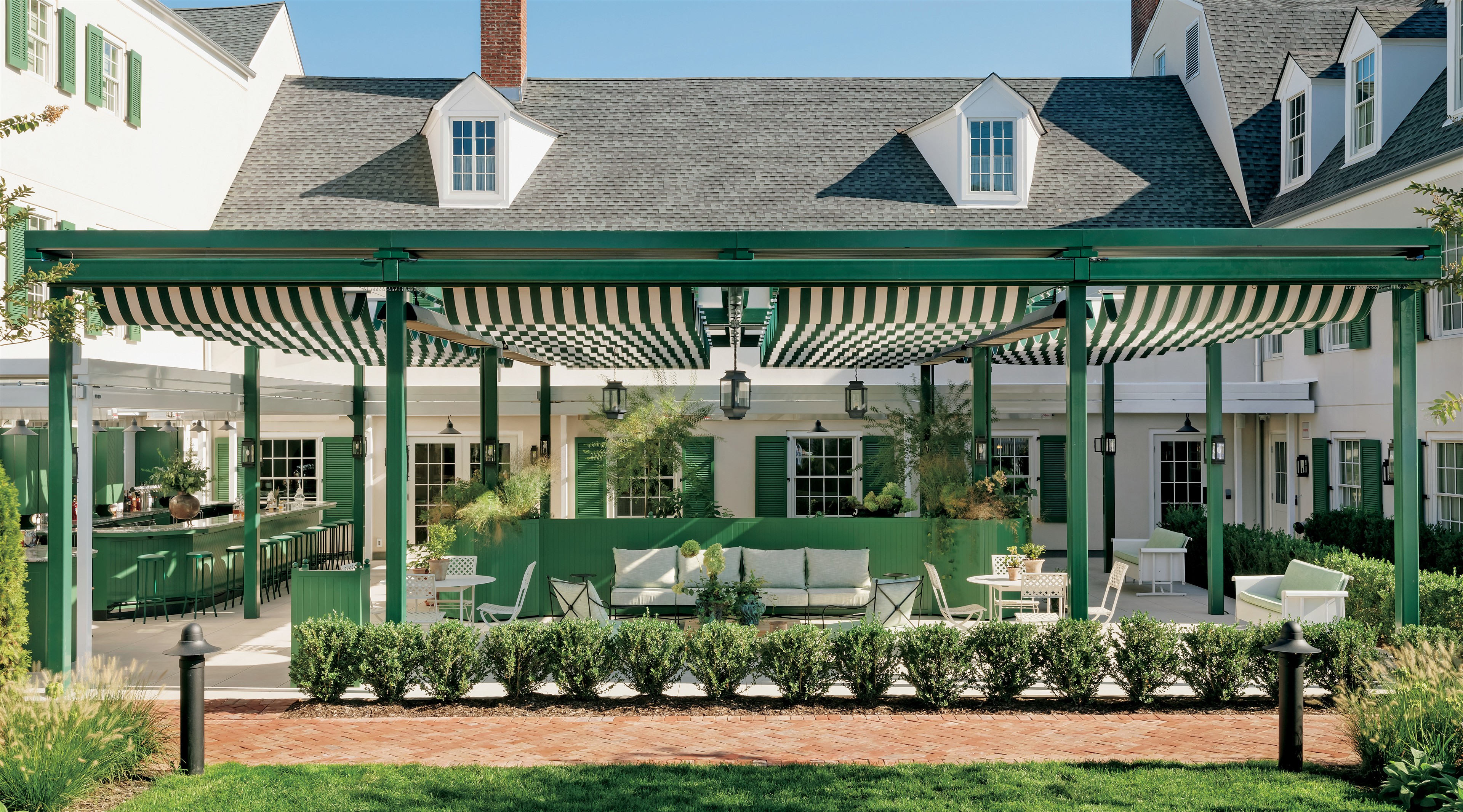 a green and white house with a covered patio