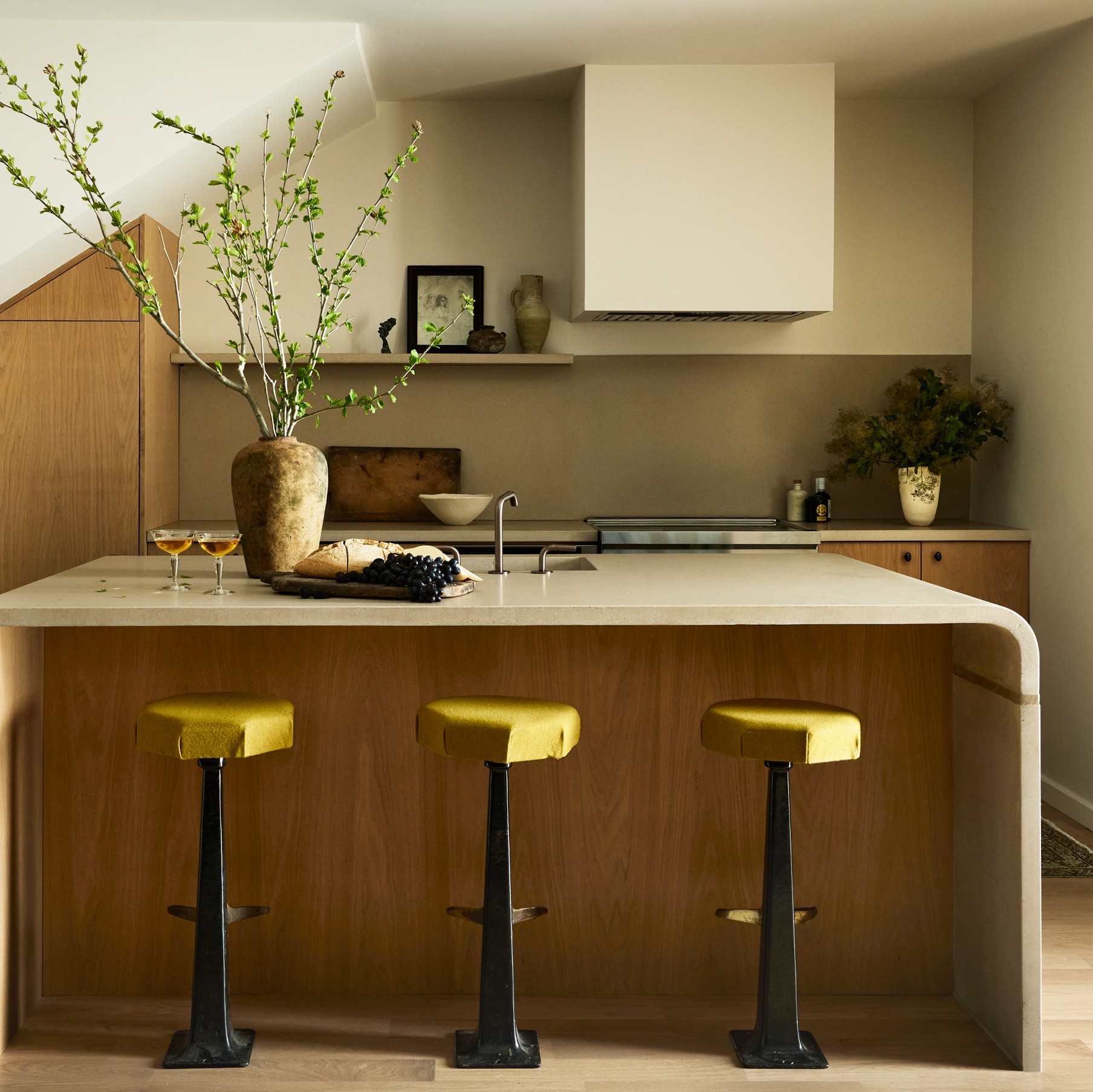 a kitchen with three stools and a center island