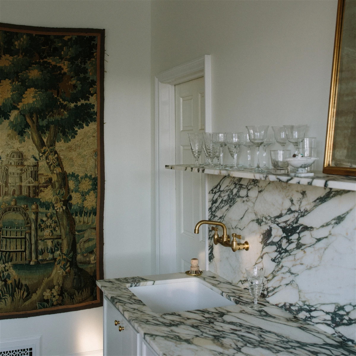 a bathroom with a sink and a tapestry on the wall