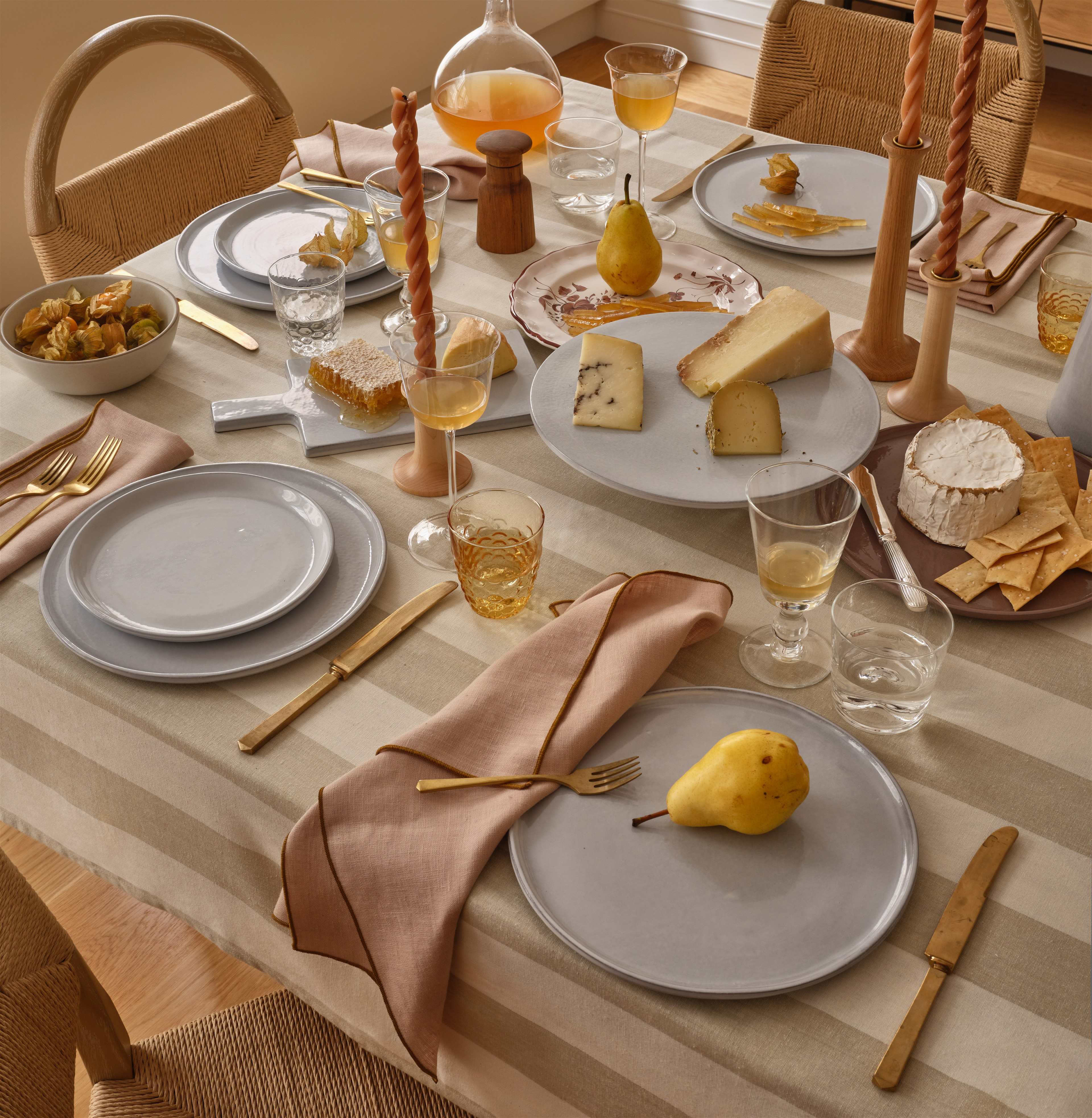 a table set with plates, silverware and a pear