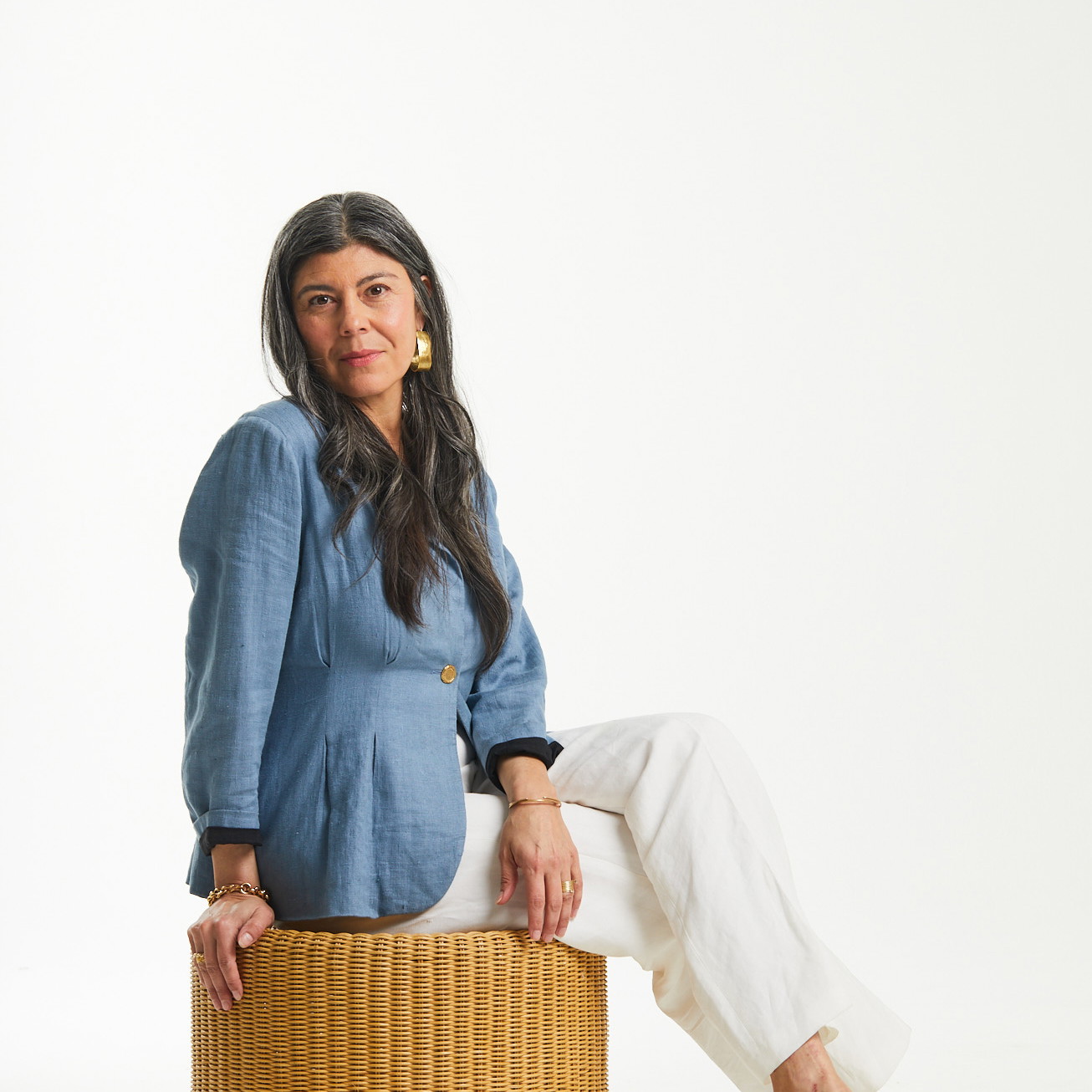 a woman sitting on top of a wooden stool