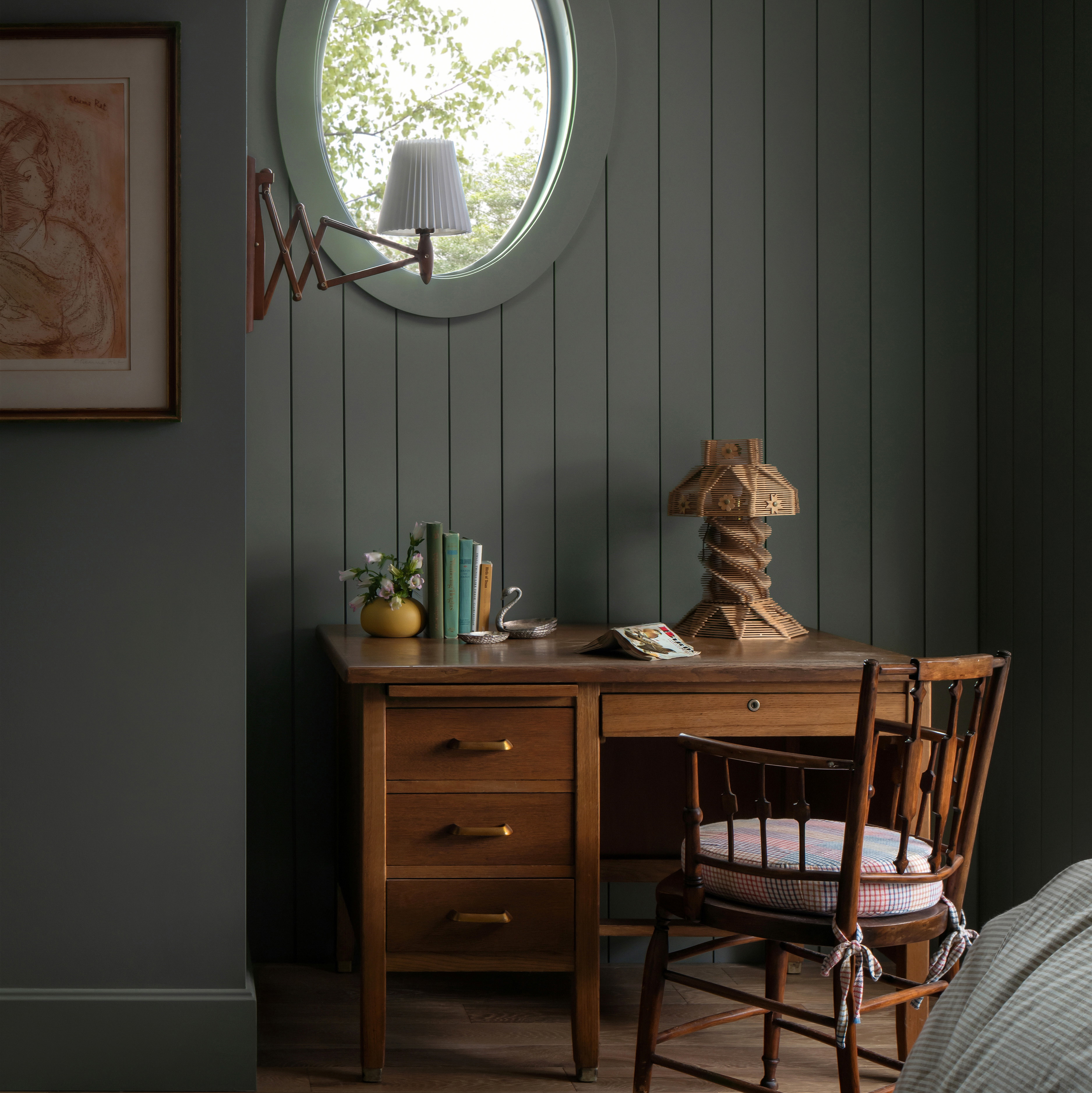 a bedroom with a desk, chair and a round window