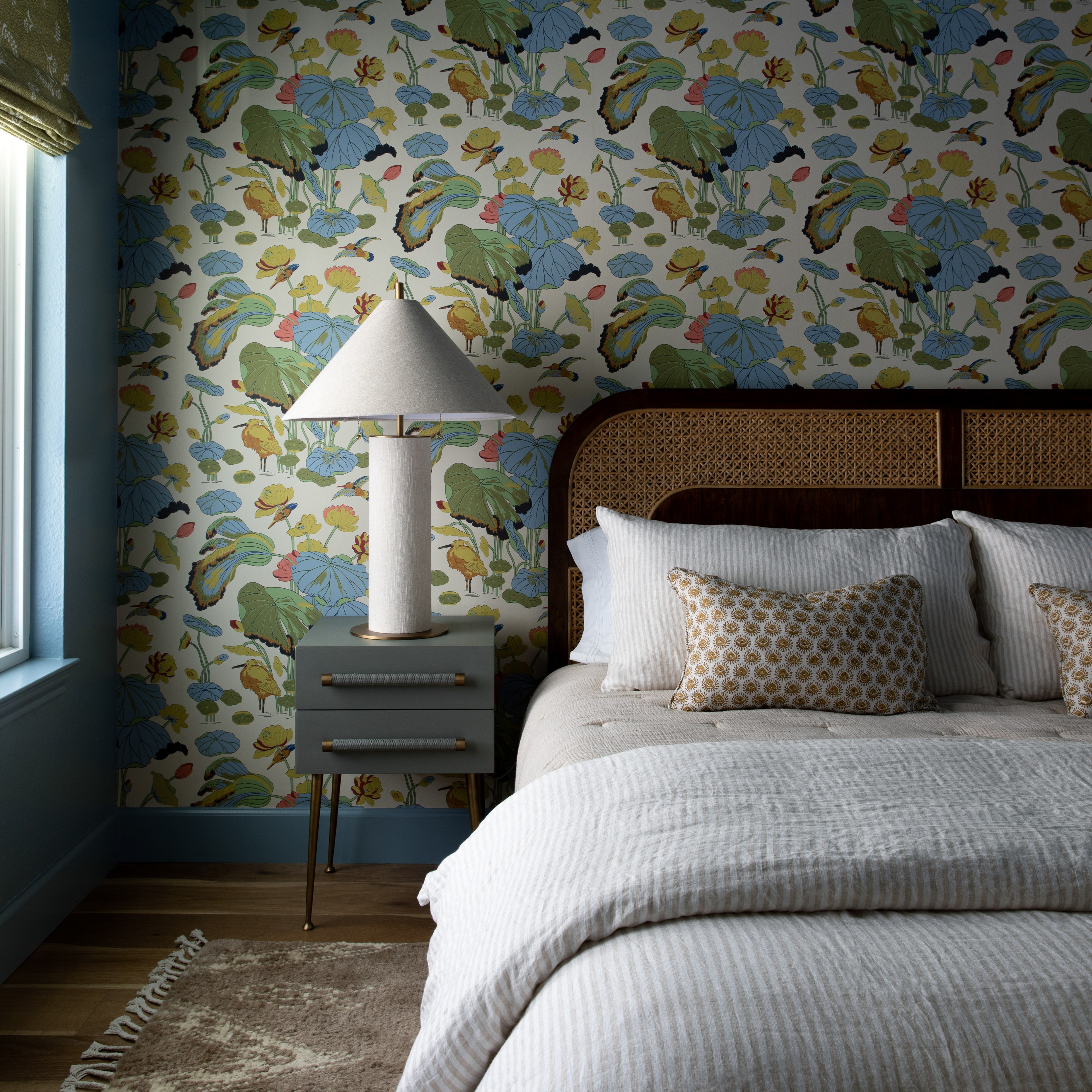 a bedroom with a floral wallpaper and a bed