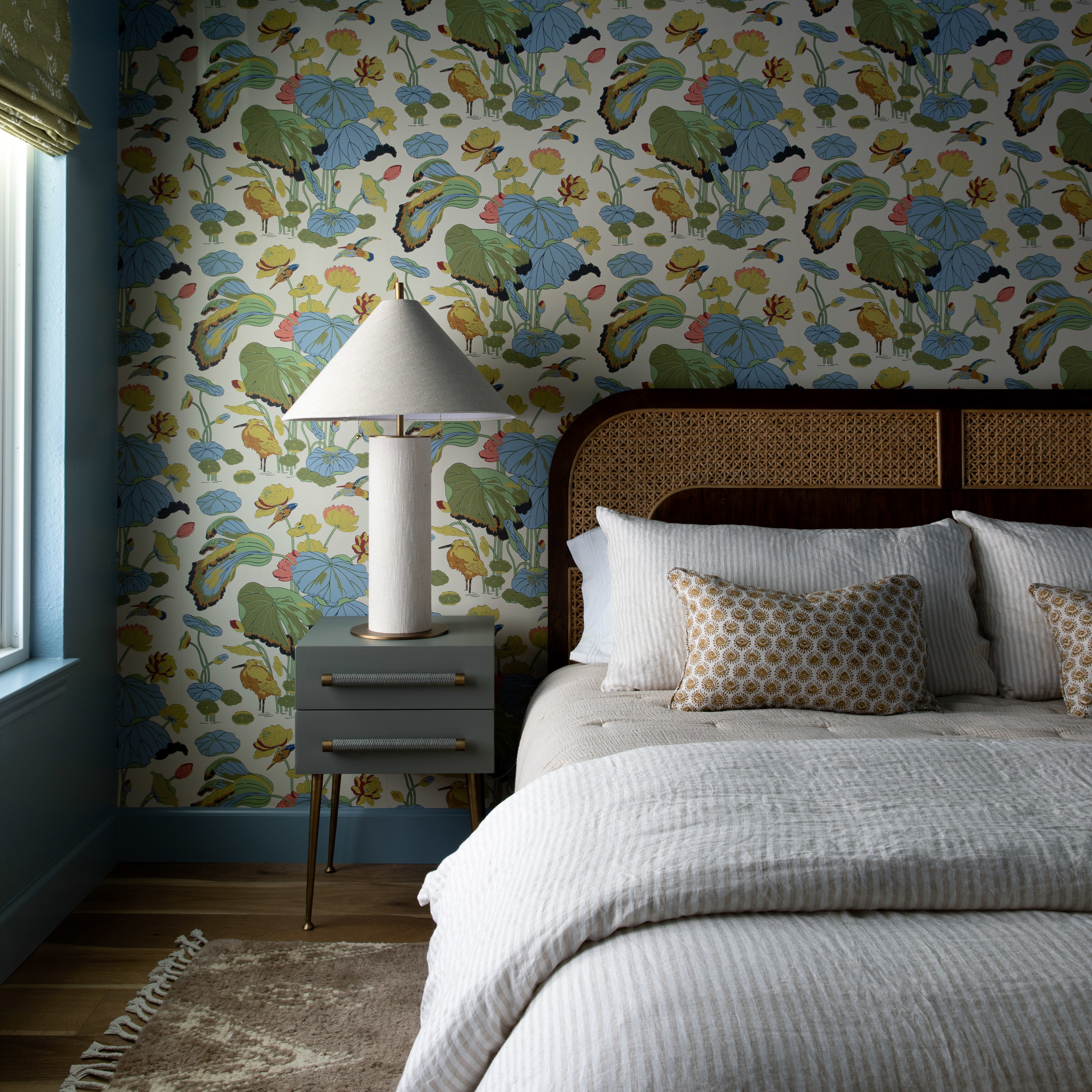 a bedroom with a floral wallpaper and a bed