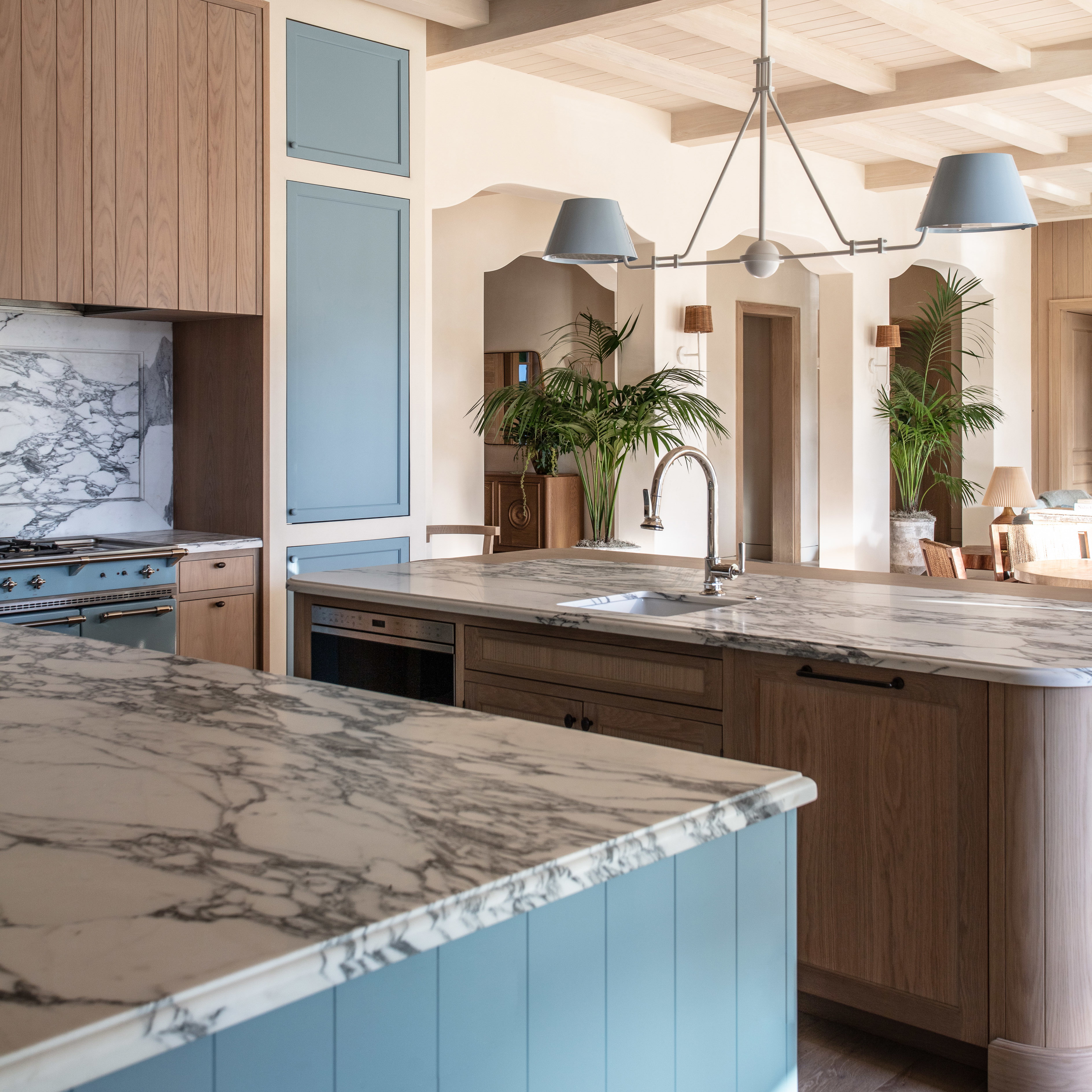 a kitchen with a marble counter top and blue cabinets