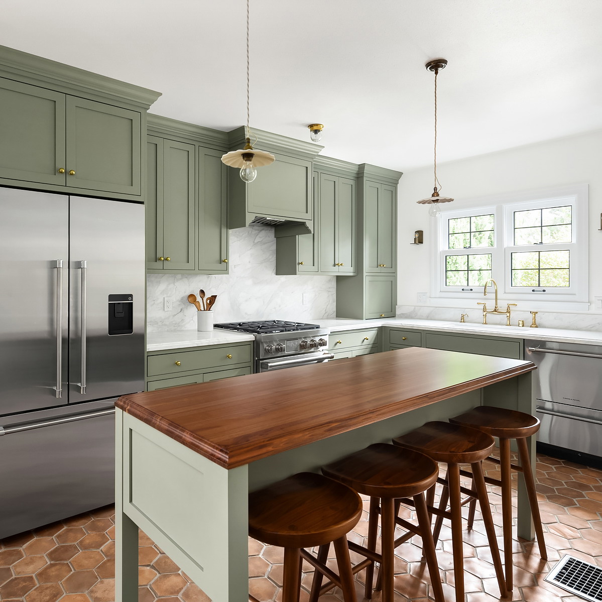 a kitchen with green cabinets and a wooden counter