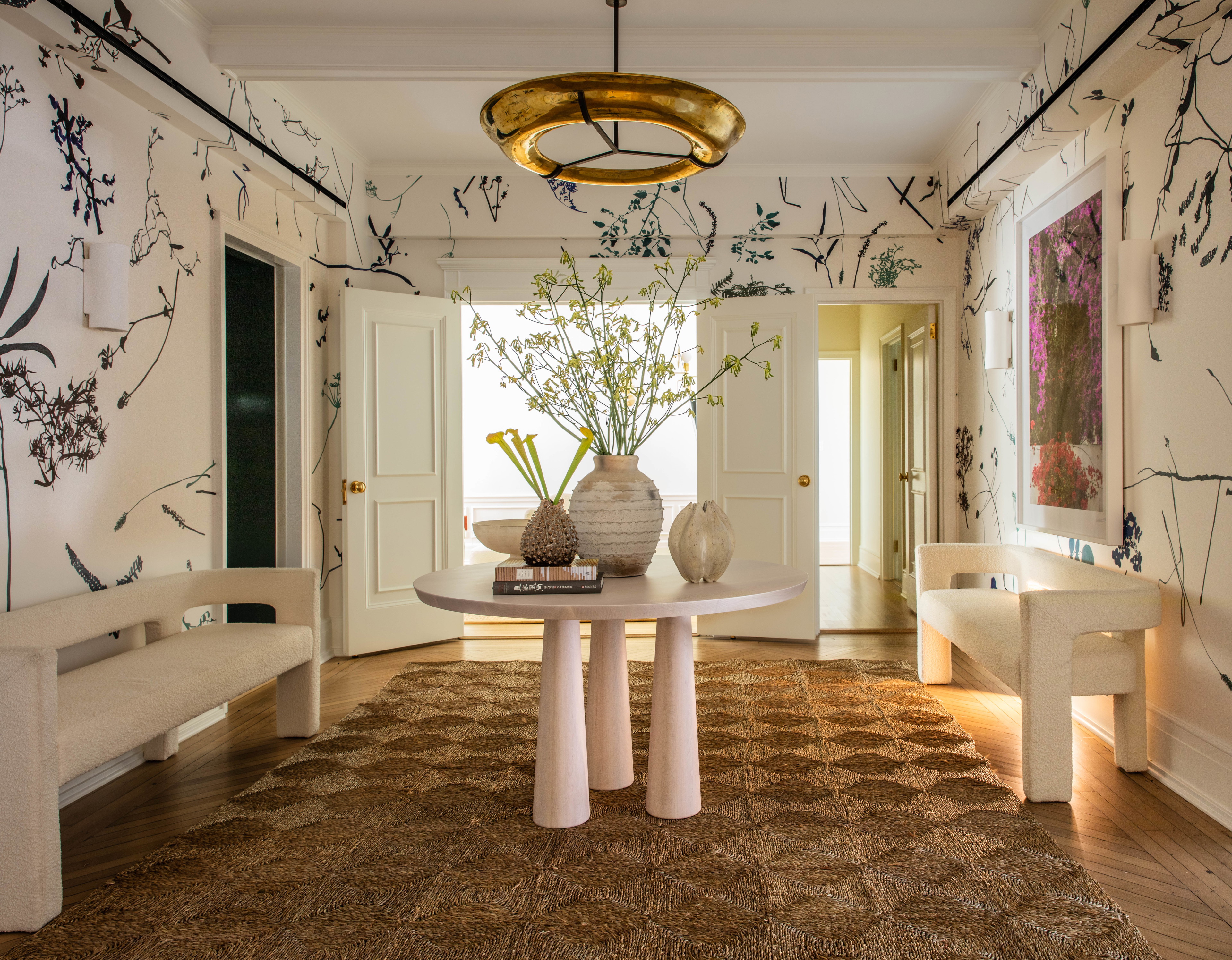 a room with a table, chairs and a vase with flowers on it