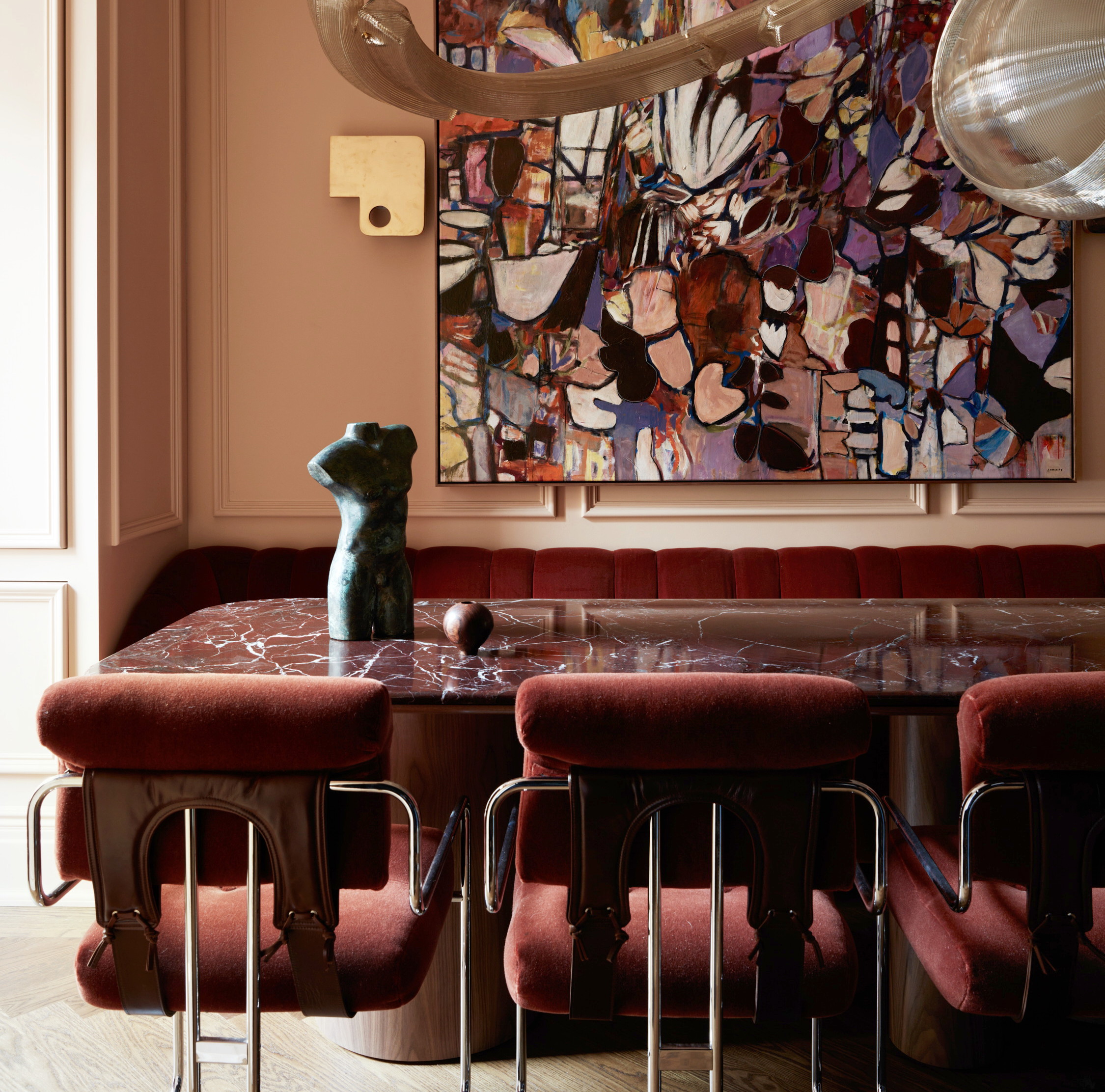 a dining room with a large painting hanging above the table