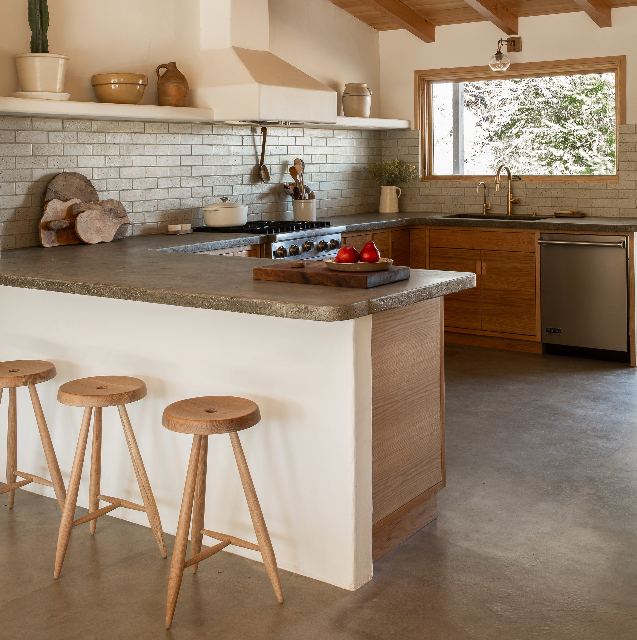 a kitchen with two stools next to a counter