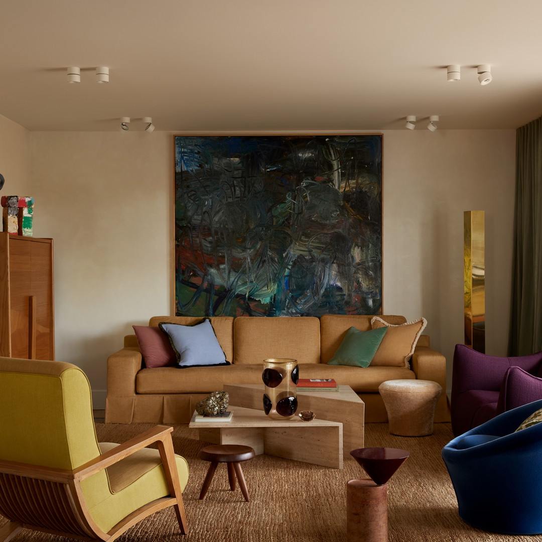 a living room filled with furniture and a painting on the wall