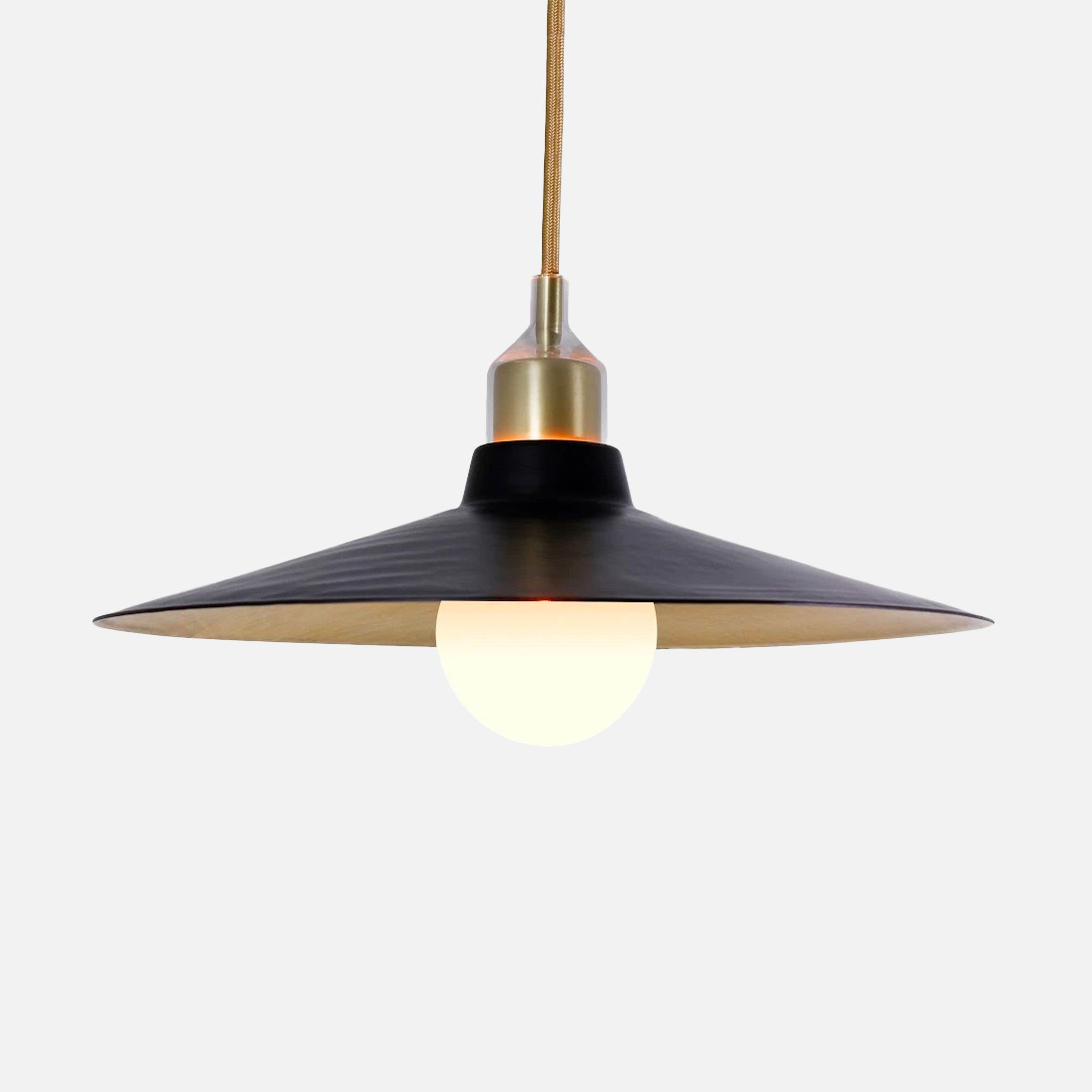 a black and gold pendant light hanging from a ceiling