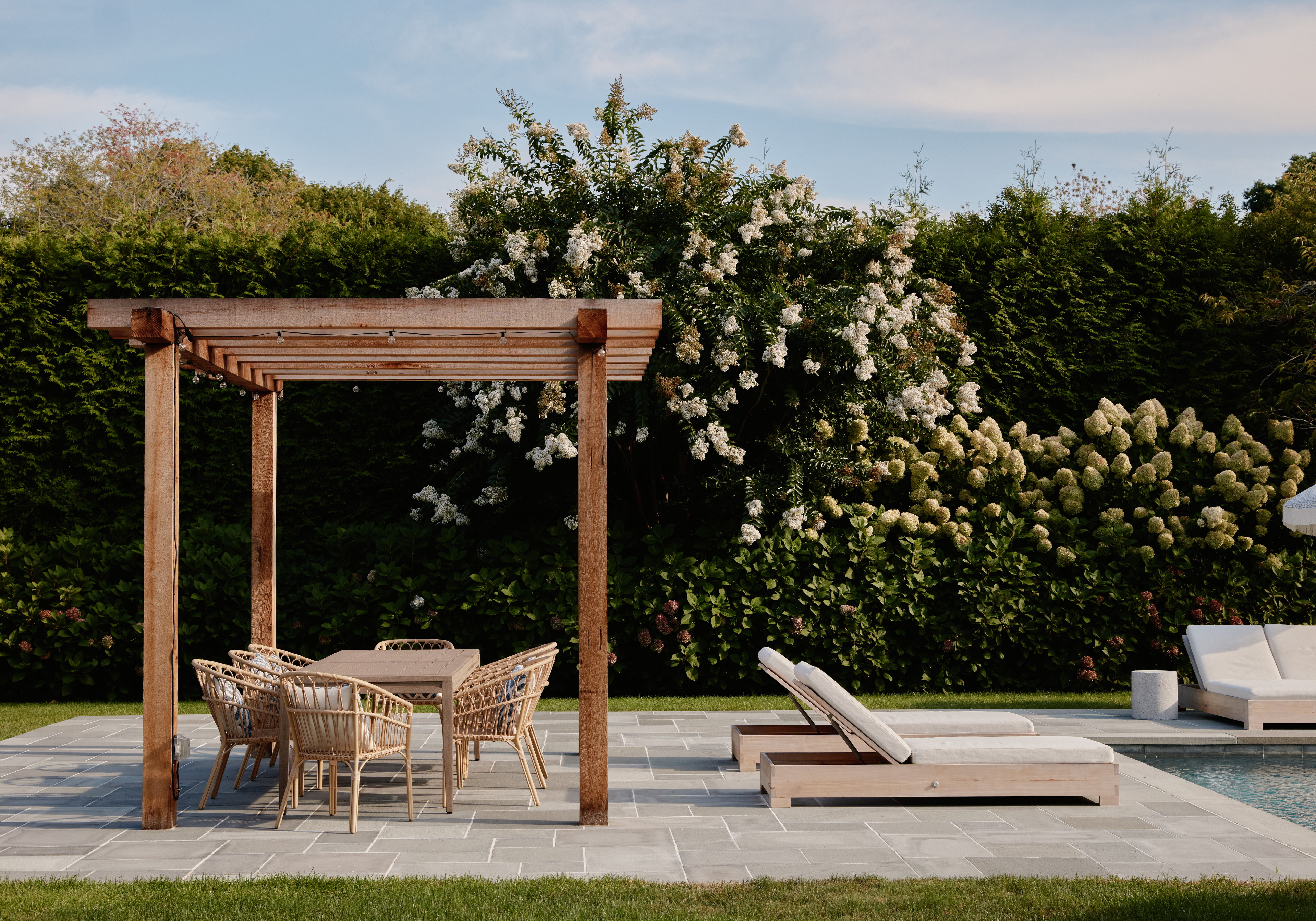 a patio with a table and chairs next to a pool