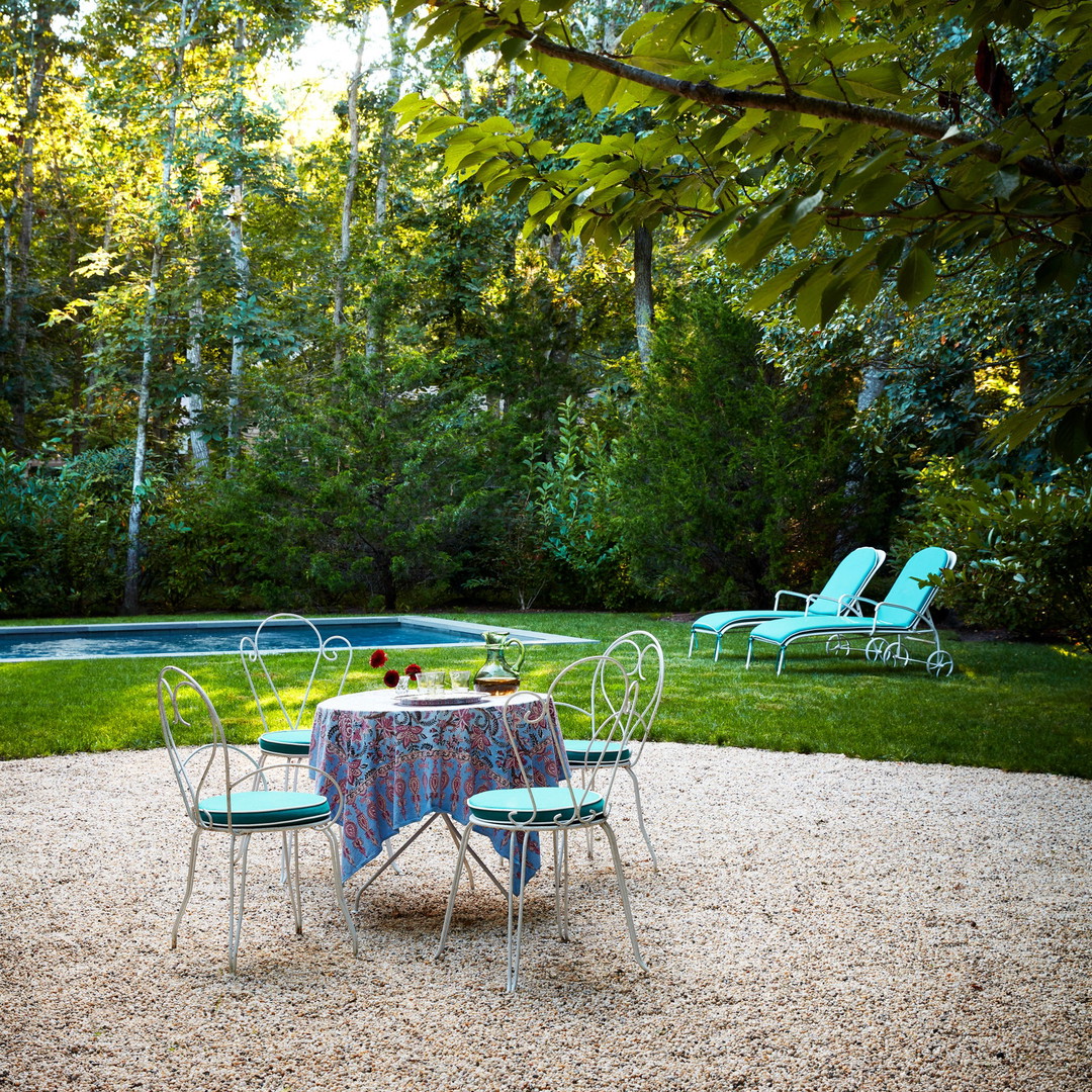 a table and chairs in a graveled area