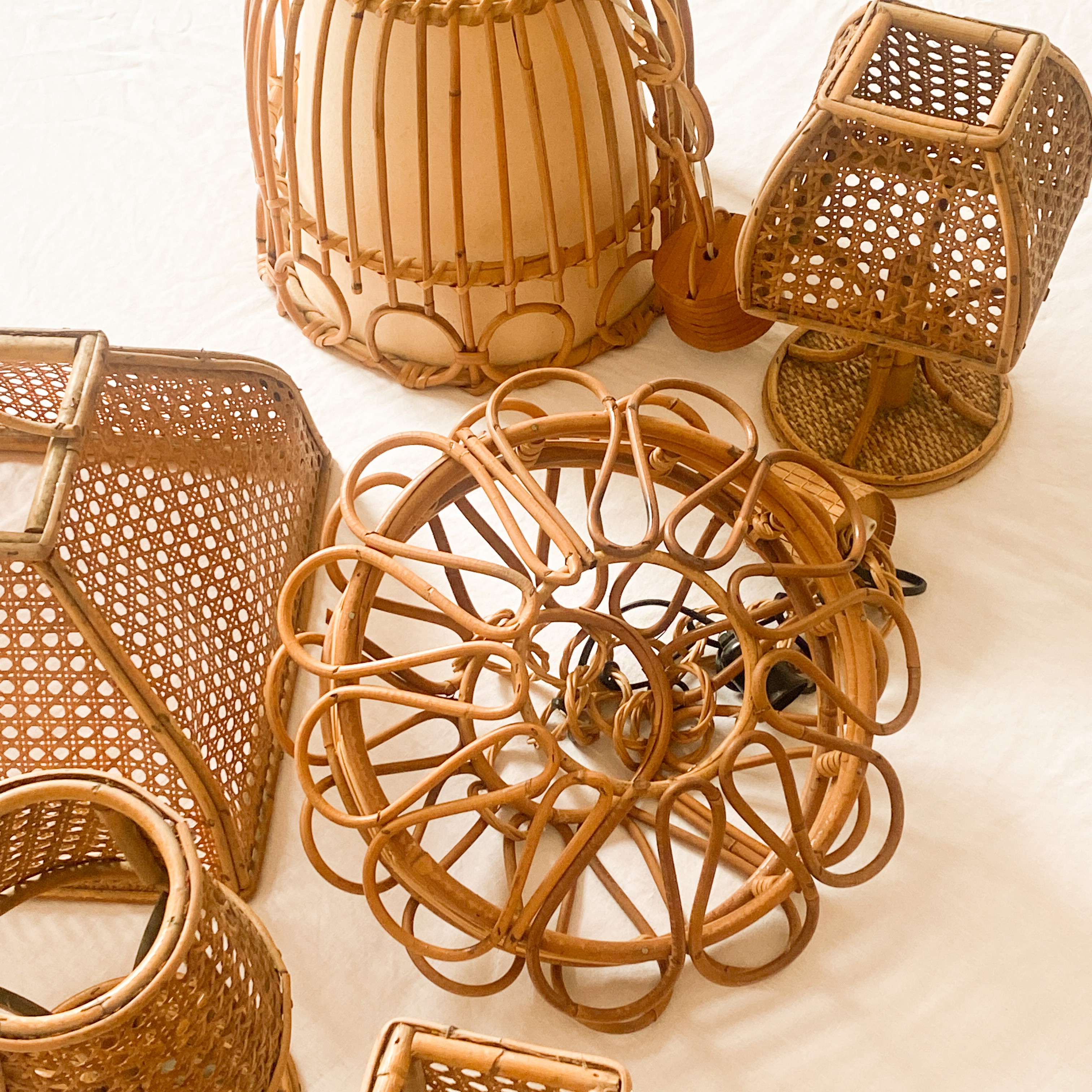 a collection of wicker baskets and baskets on a bed