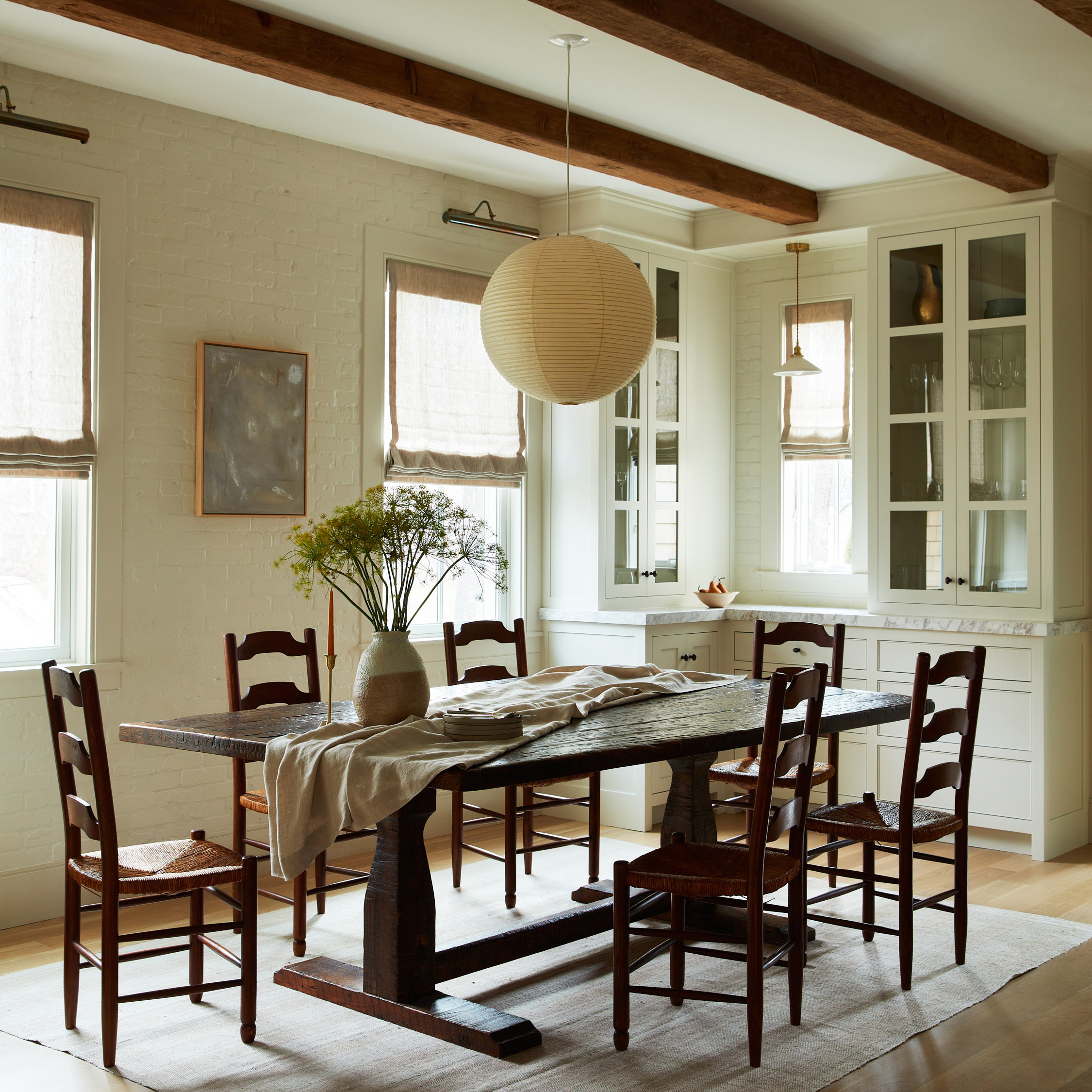 a dining room table with a vase of flowers on it