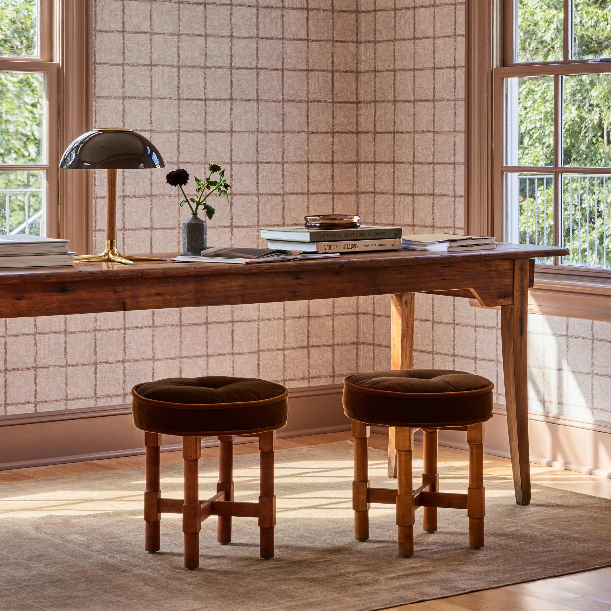 a desk with two stools and a lamp