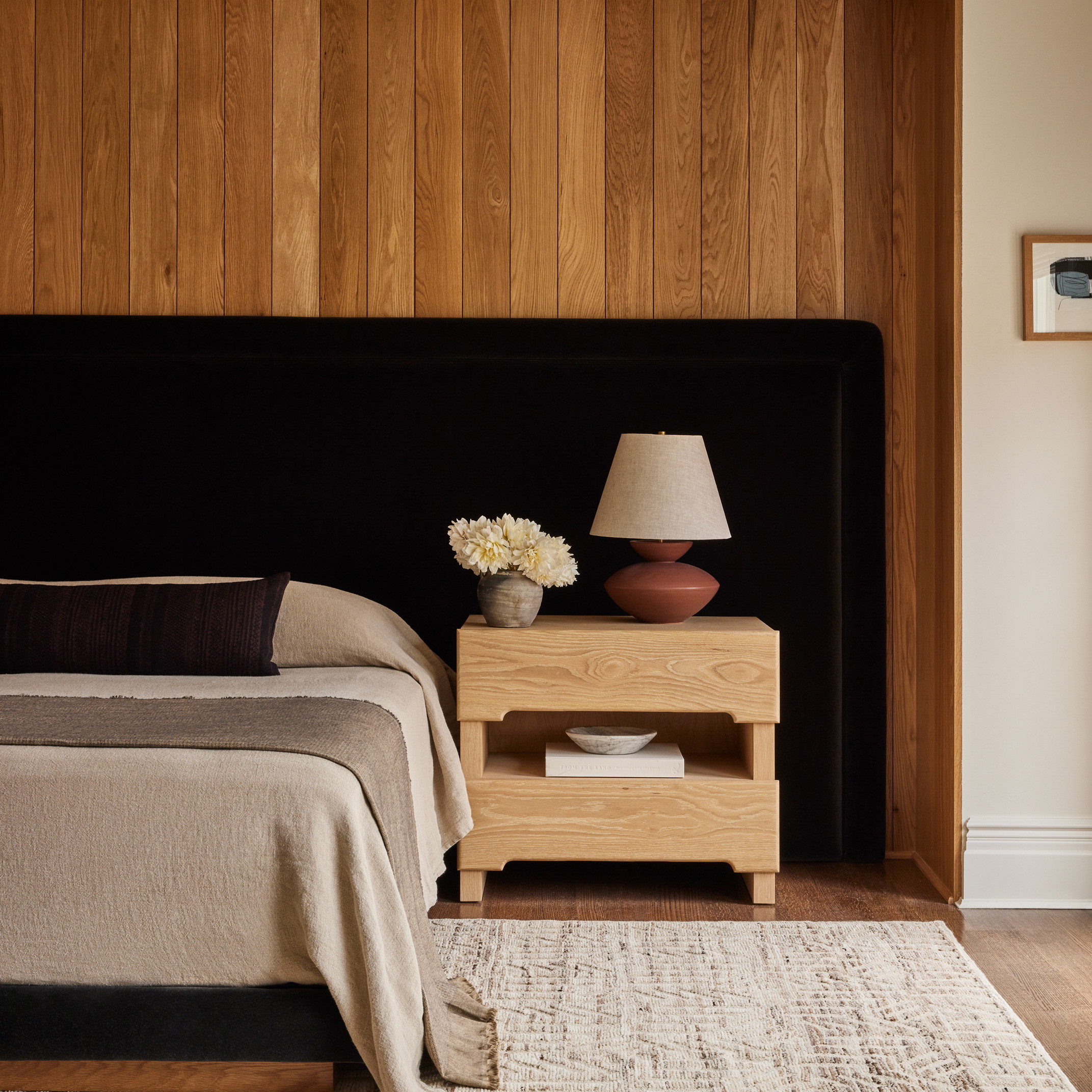 a bedroom with wood paneling and a bed