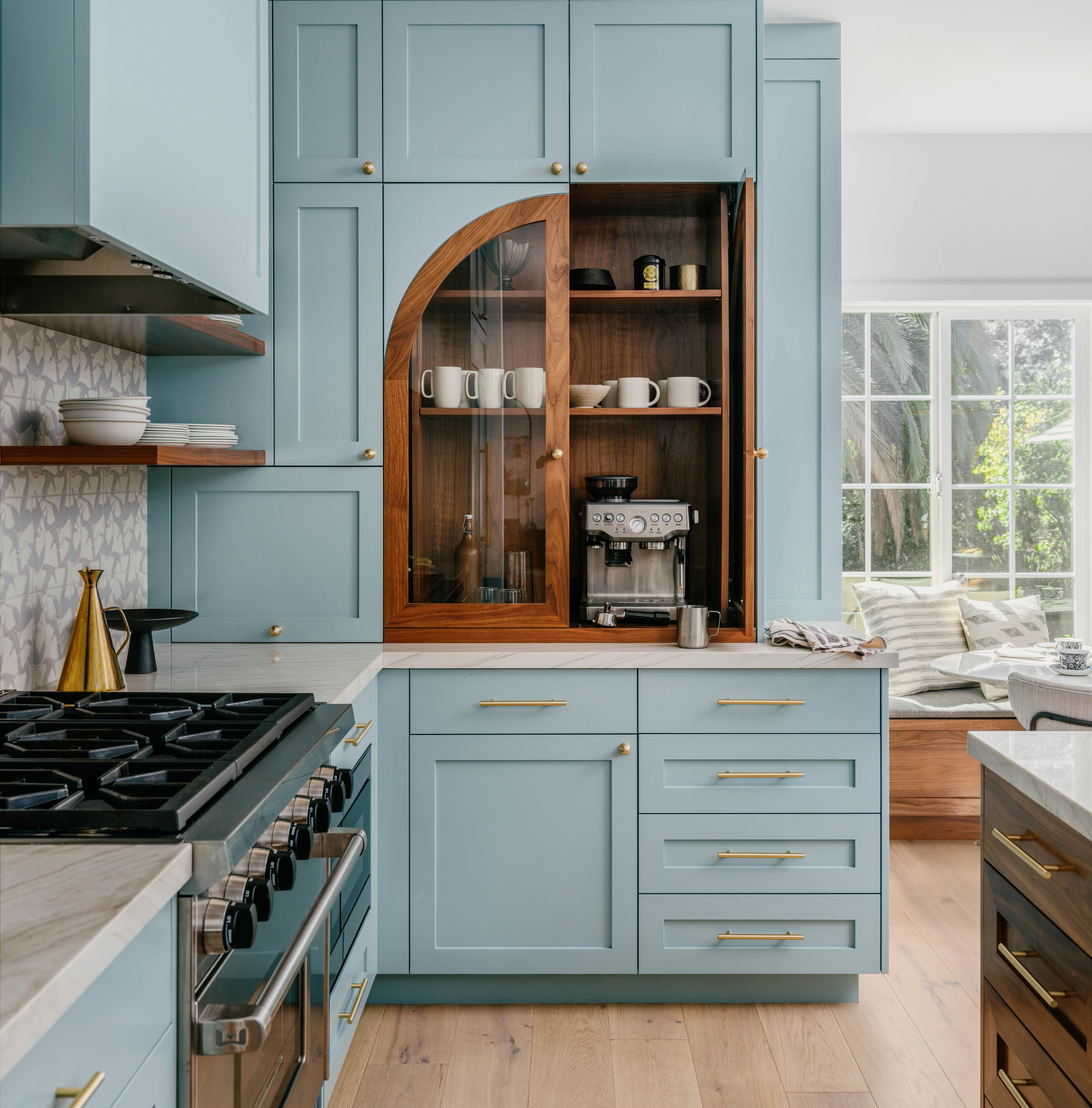 a kitchen with blue cabinets and wooden floors