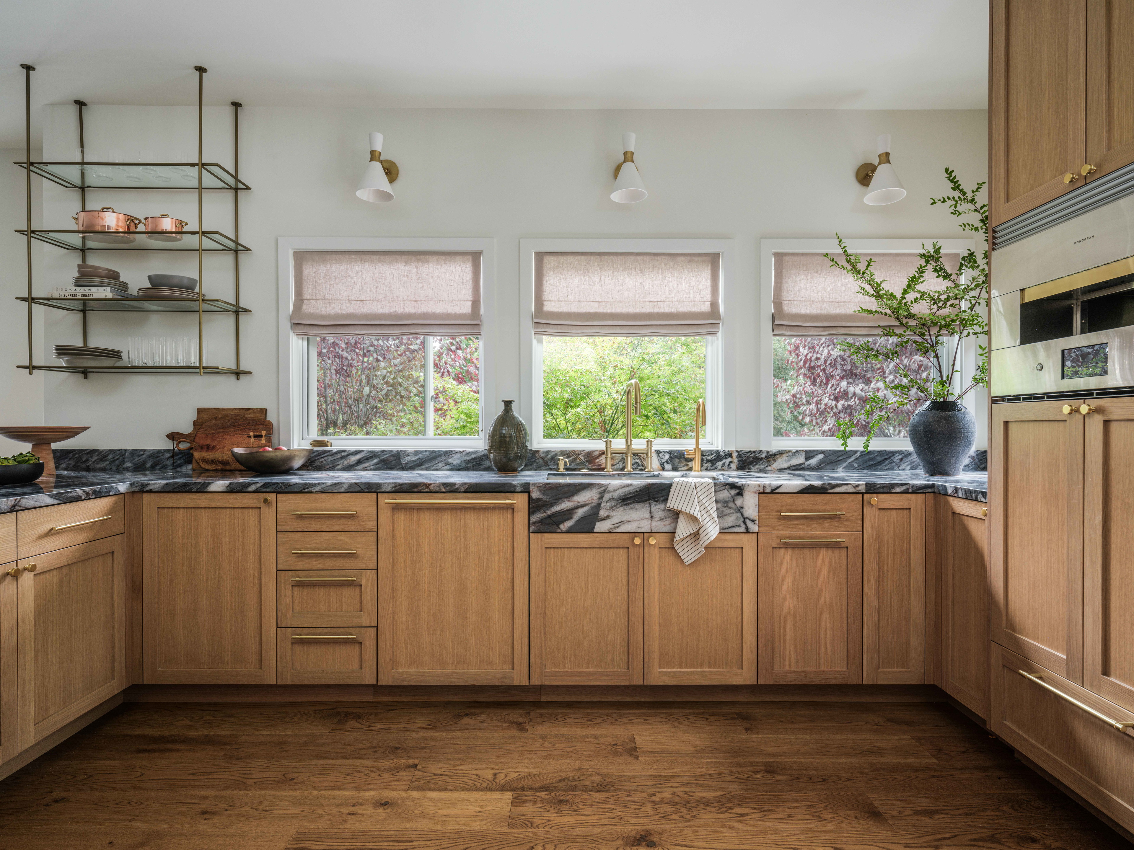 a kitchen with wooden cabinets and marble counter tops