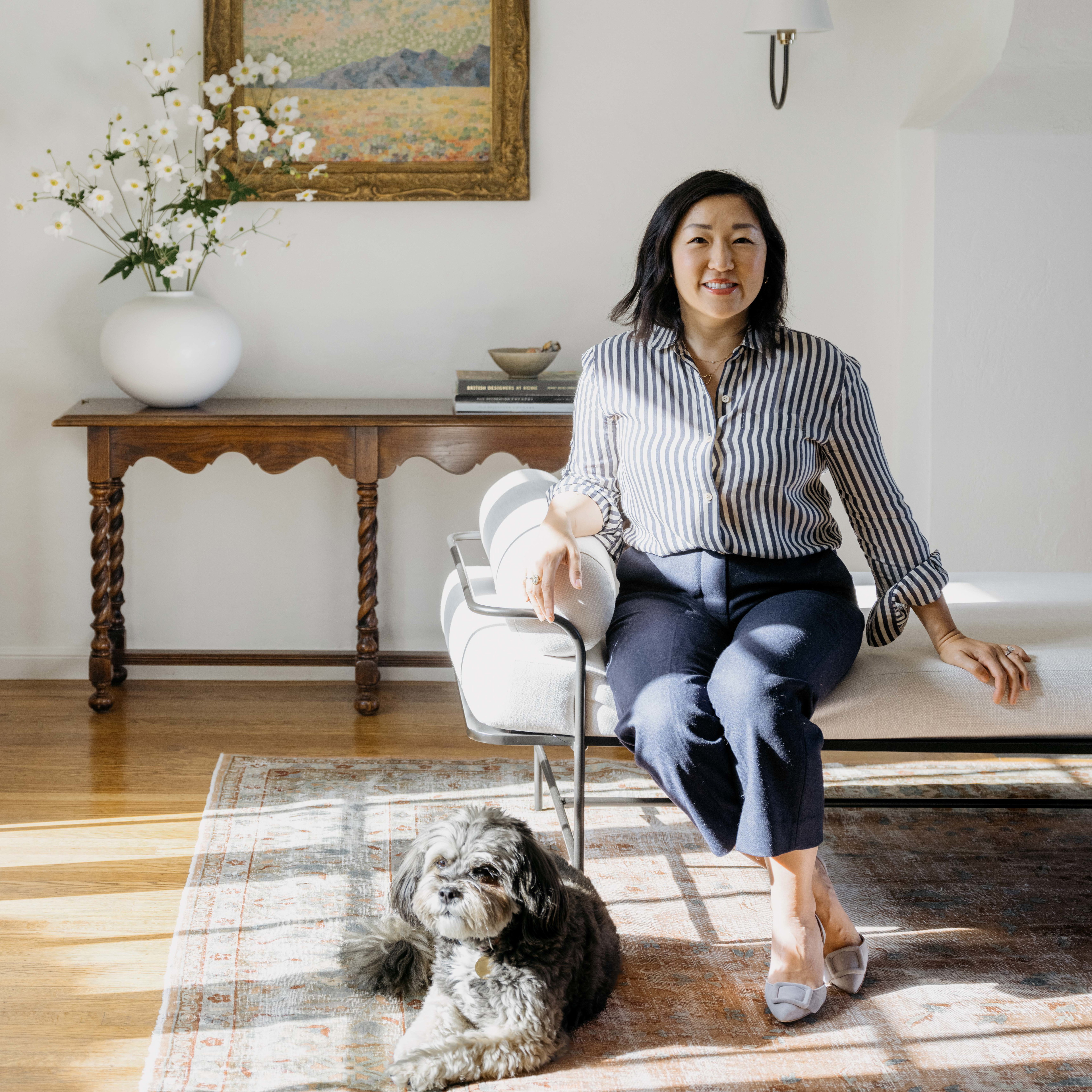 a woman sitting on a chair next to a dog