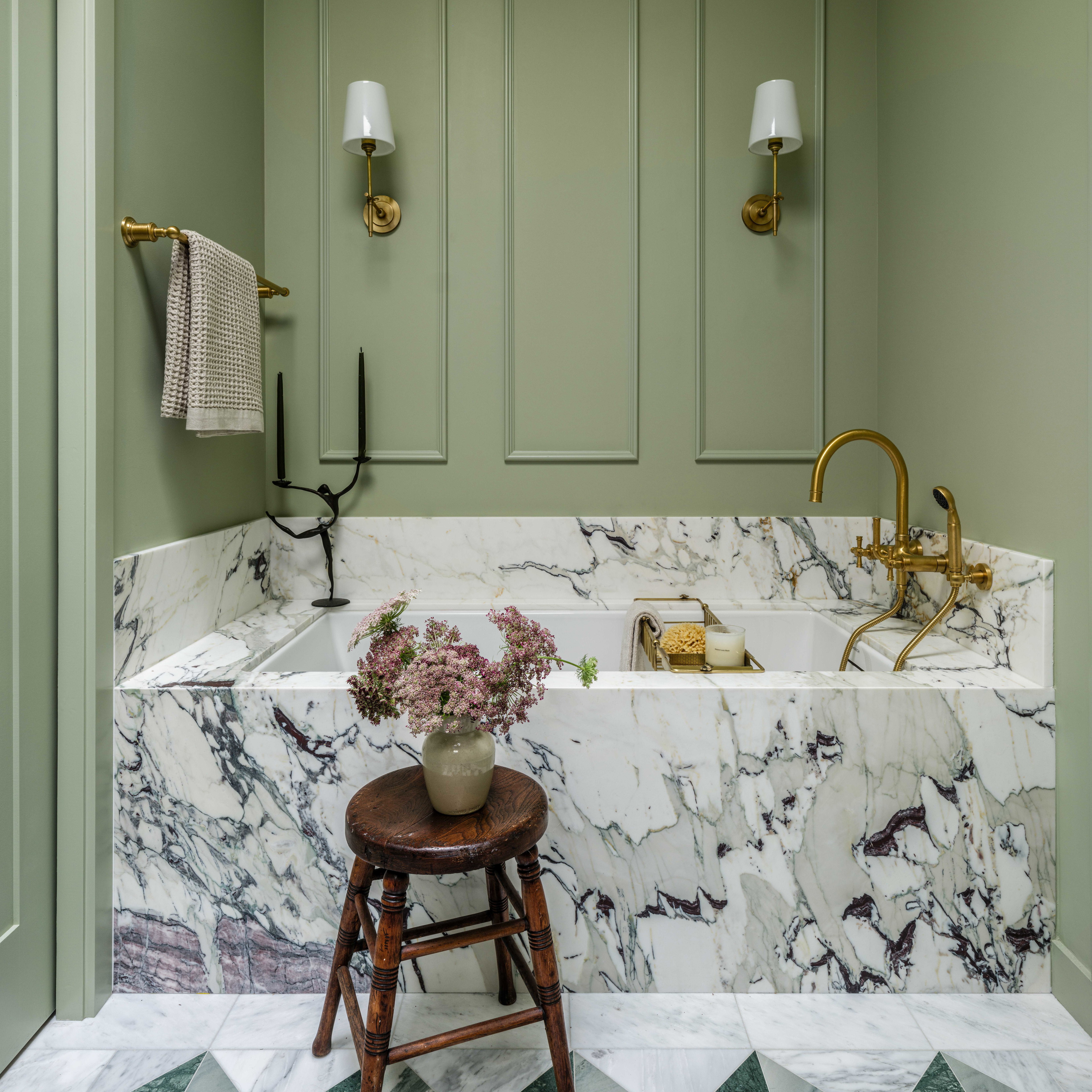 a bathroom with green walls and a marble sink