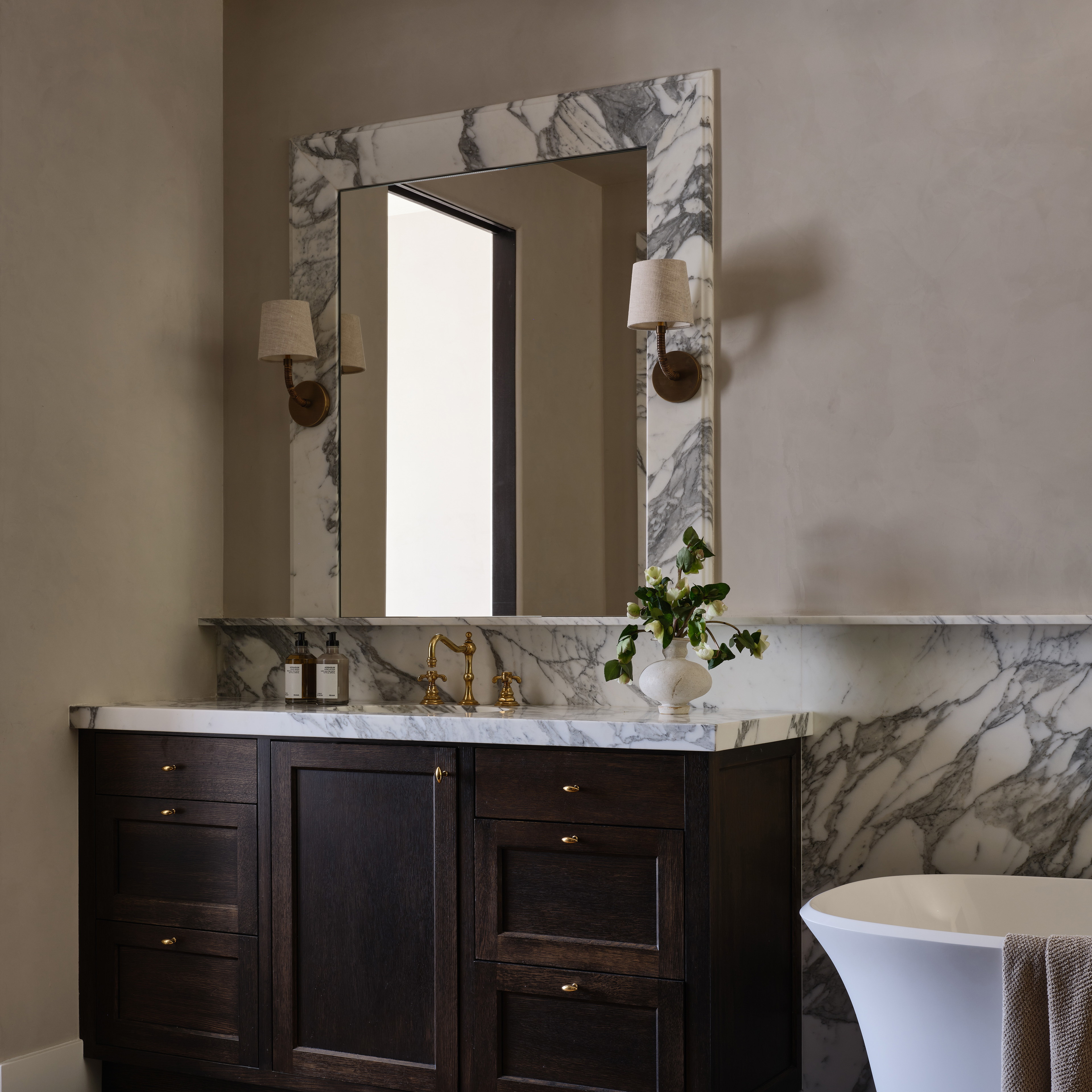 a bath room with a sink a mirror and a bath tub