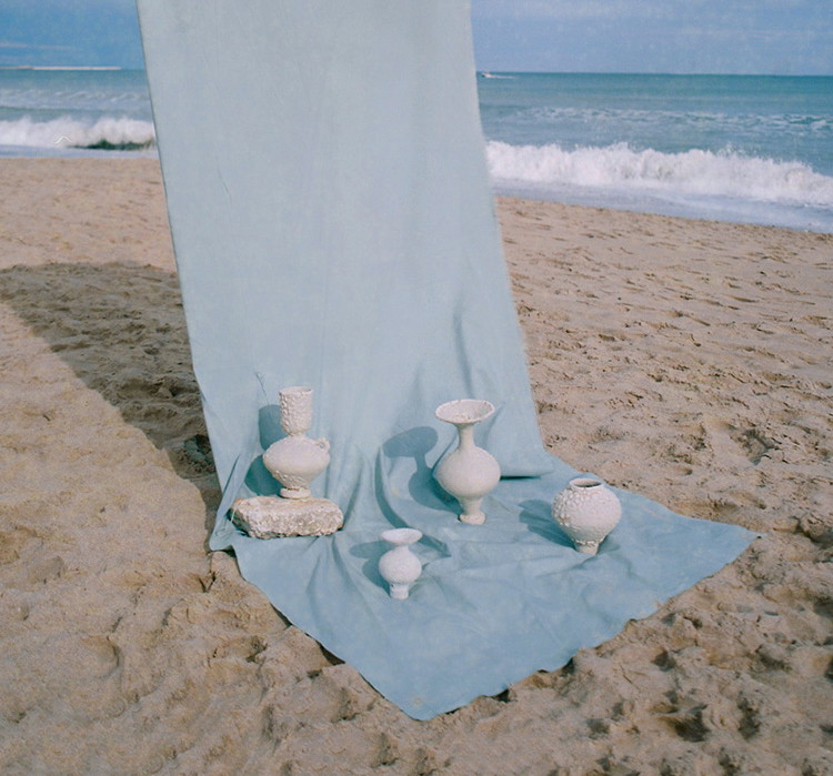 a blue blanket on a beach next to the ocean