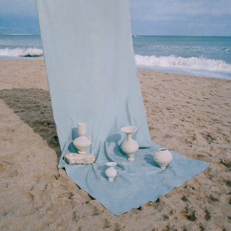 a blue blanket on a beach next to the ocean