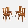 a set of four wooden chairs sitting next to each other