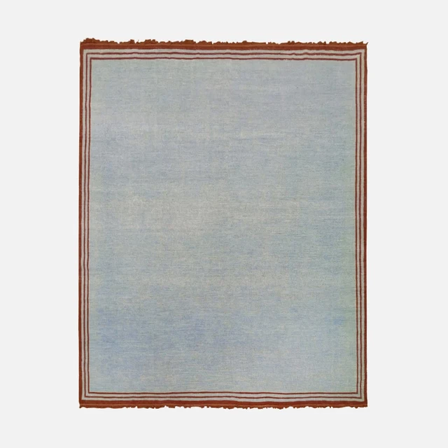 a blue rug with a brown border on a white background