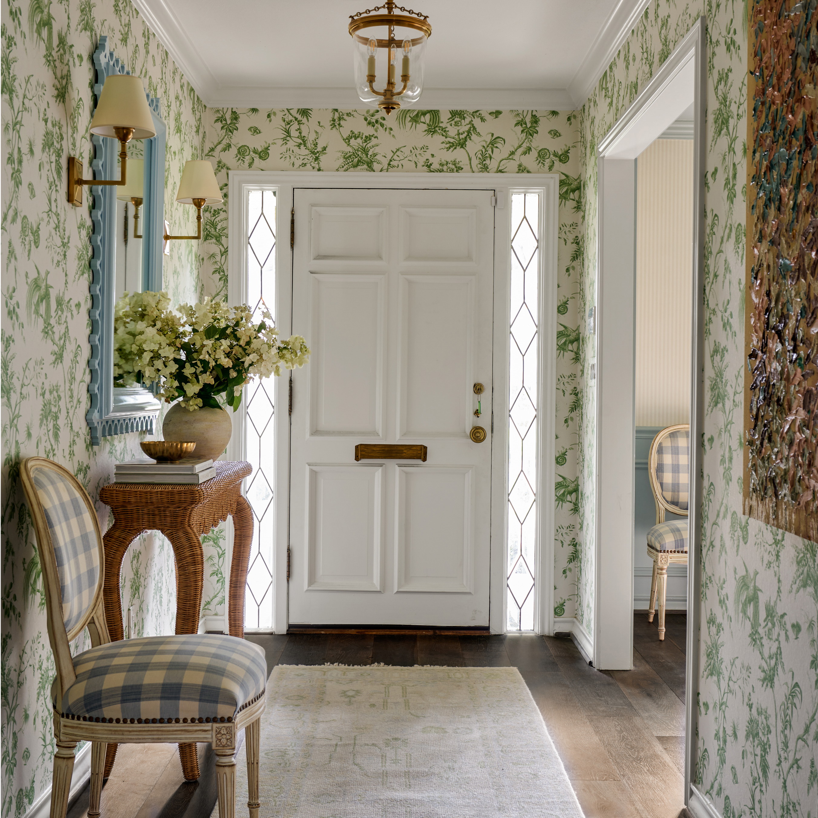 a hallway with a chair and a vase of flowers