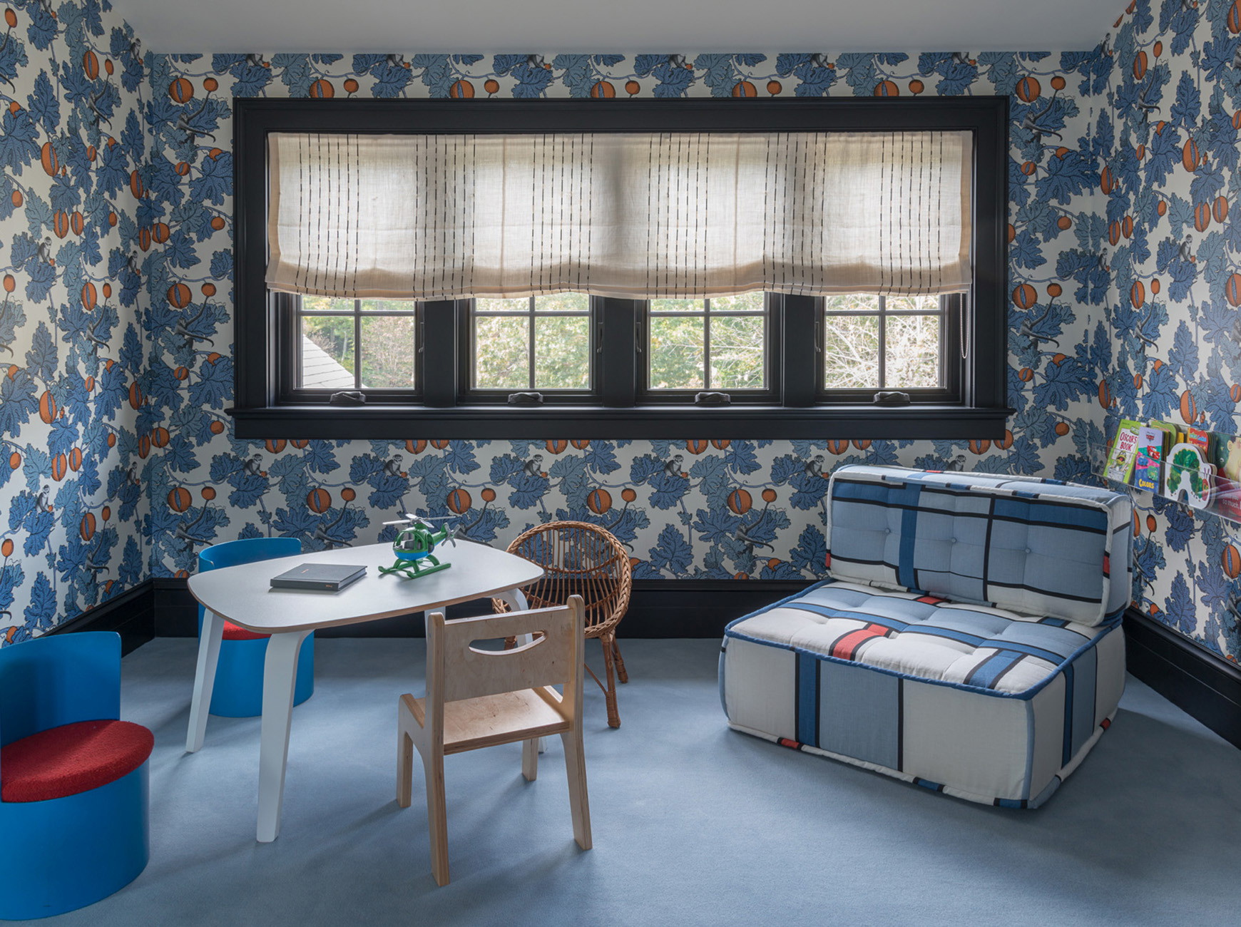 a child's room with a table, chair, and suitcase