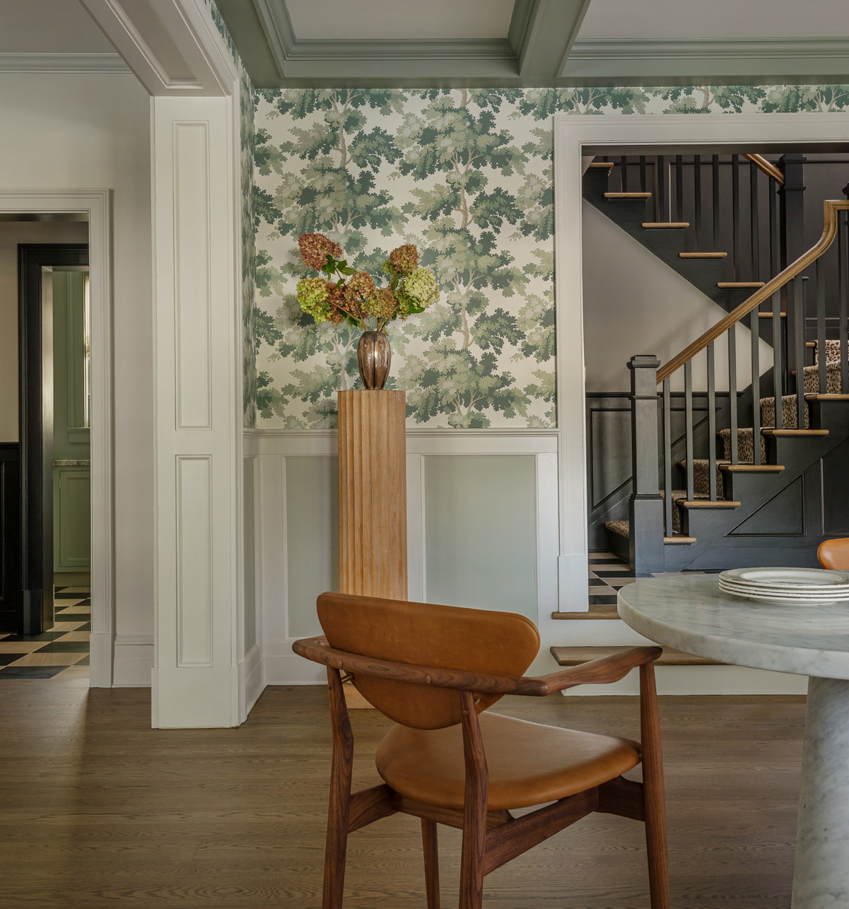 a room with a table, chairs and a vase with flowers on it