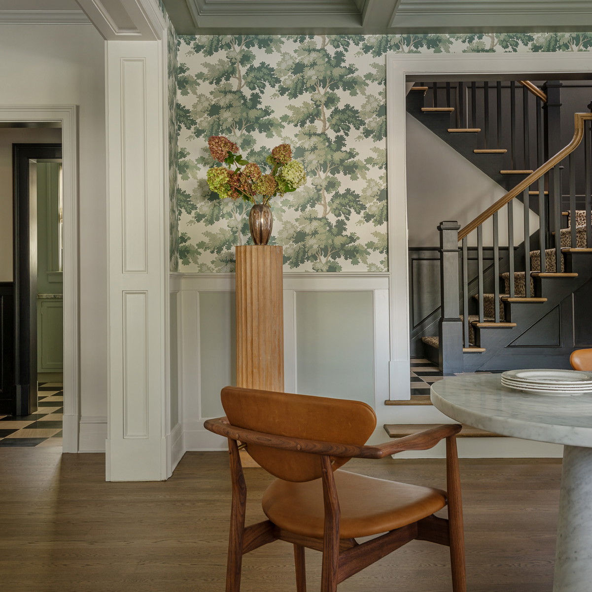 a room with a table, chairs and a vase with flowers on it