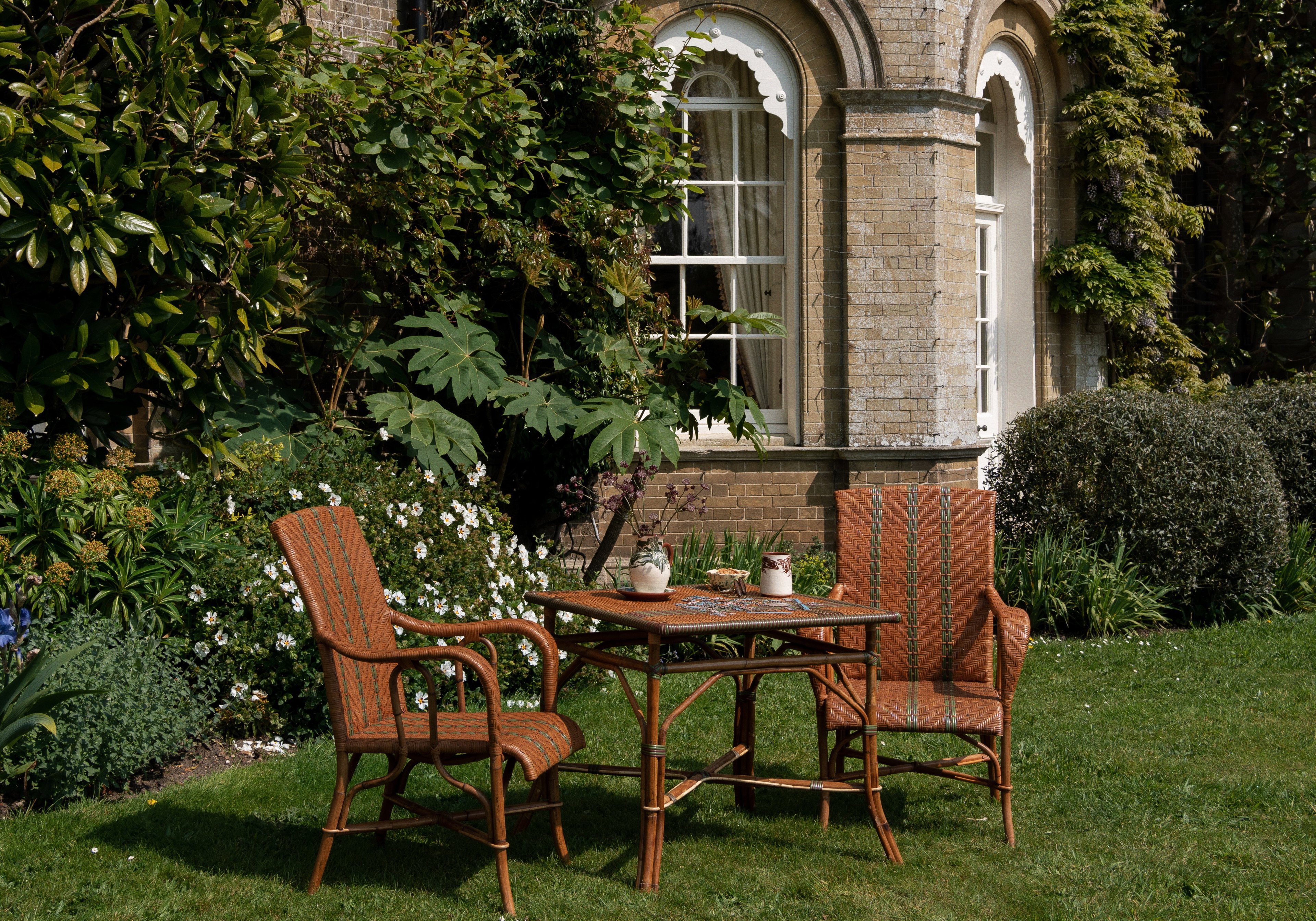 a couple of wooden chairs sitting on top of a lush green field