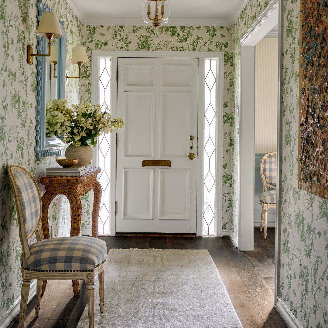 a hallway with a chair and a vase of flowers