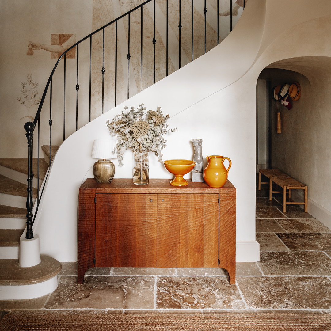 a room with a staircase and a painting on the wall