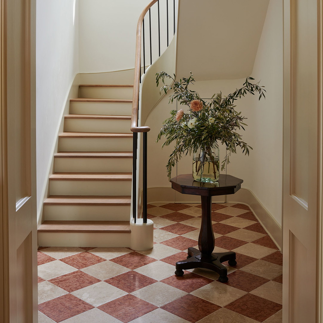 a foyer with a chandelier and a checkered floor