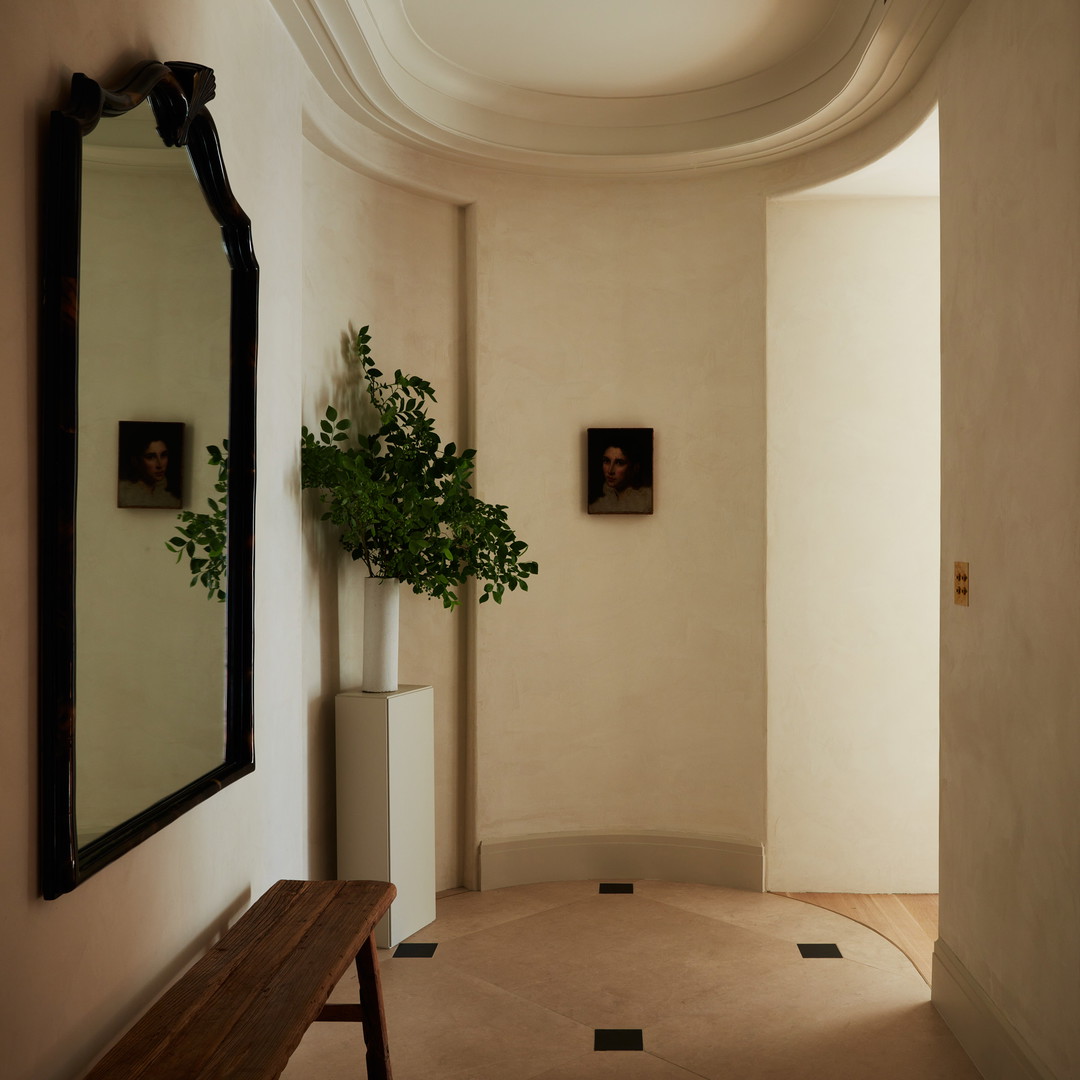 a hallway with a bench and a mirror