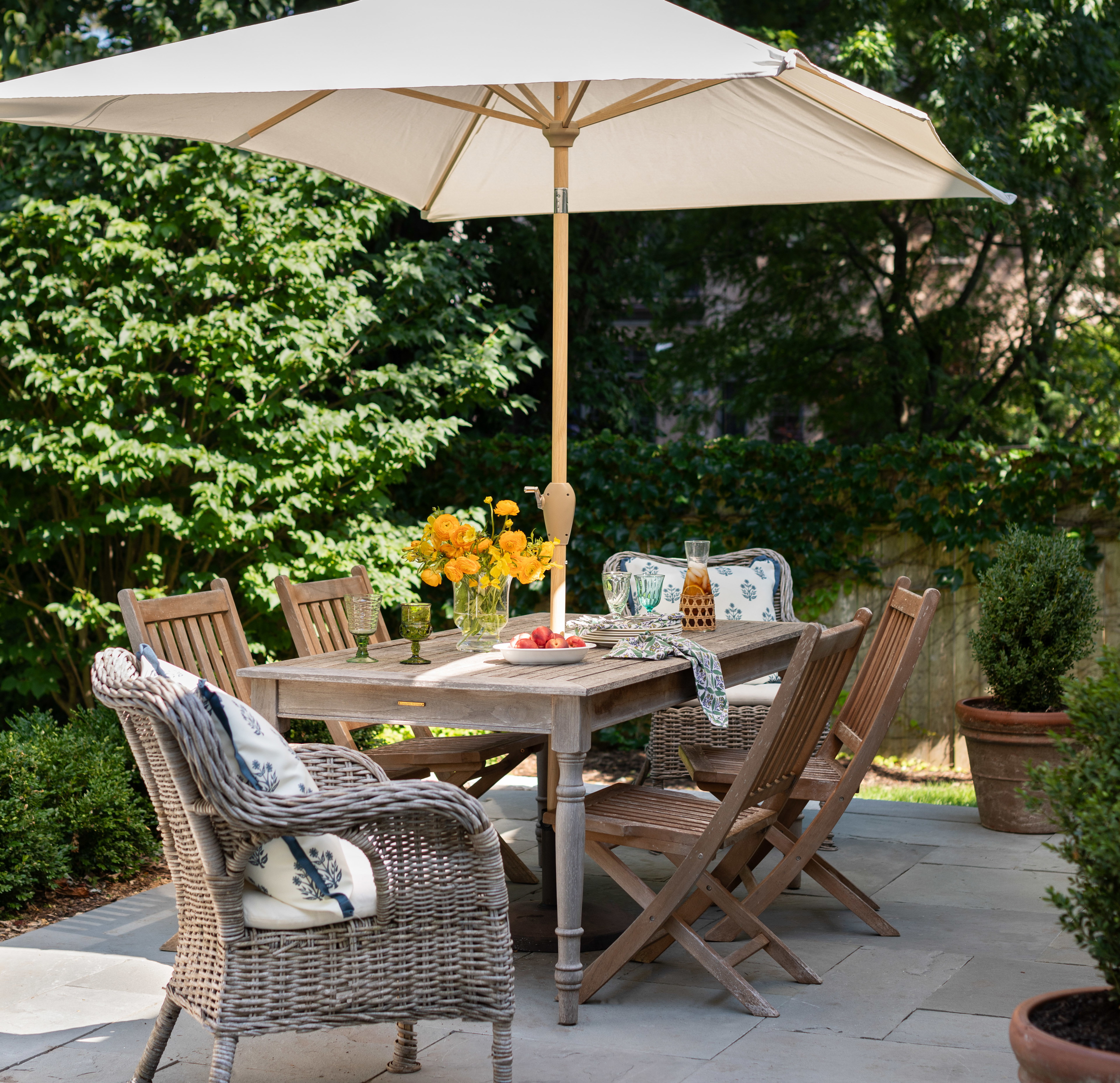 a patio with a table and chairs under an umbrella