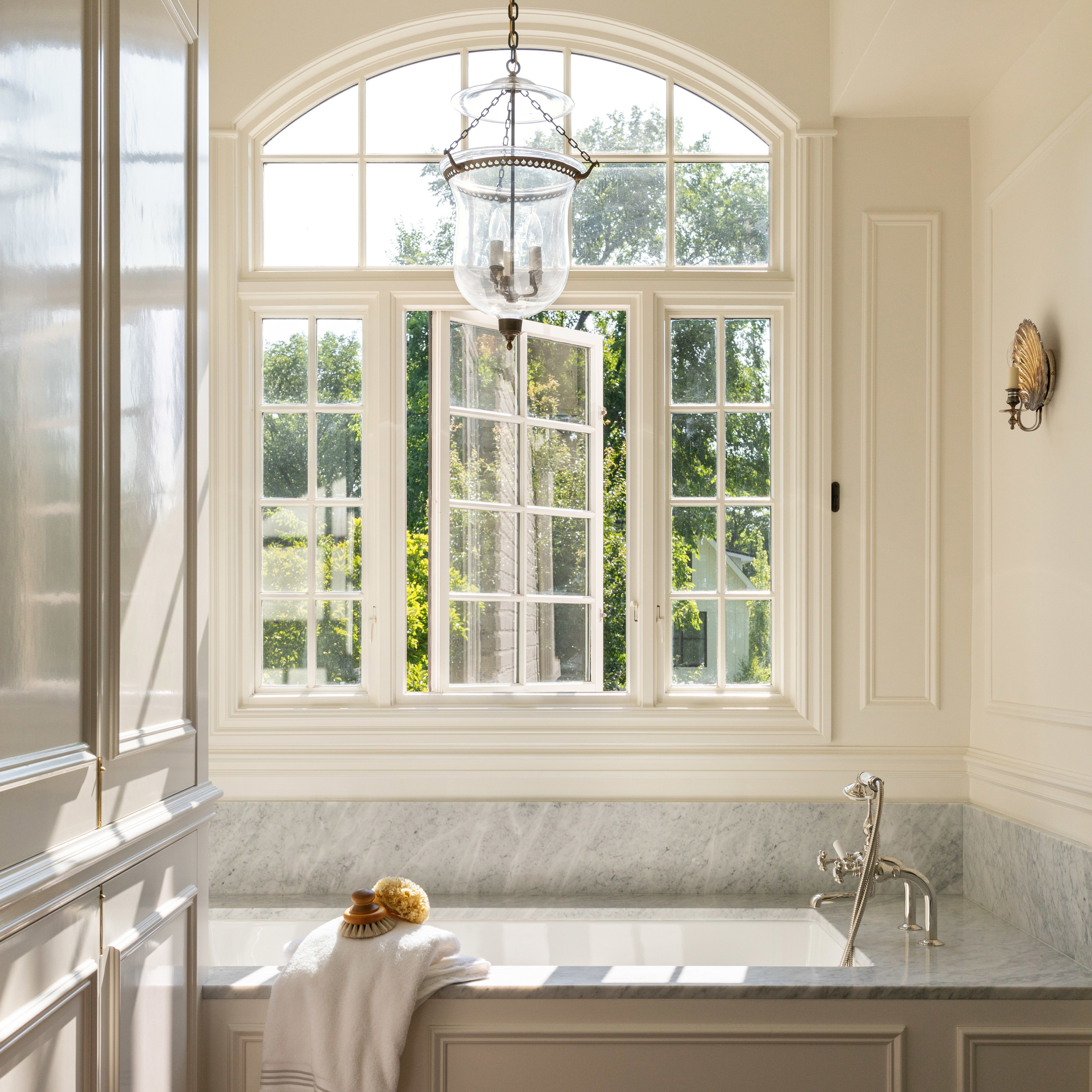 a bathroom with a tub and a chandelier