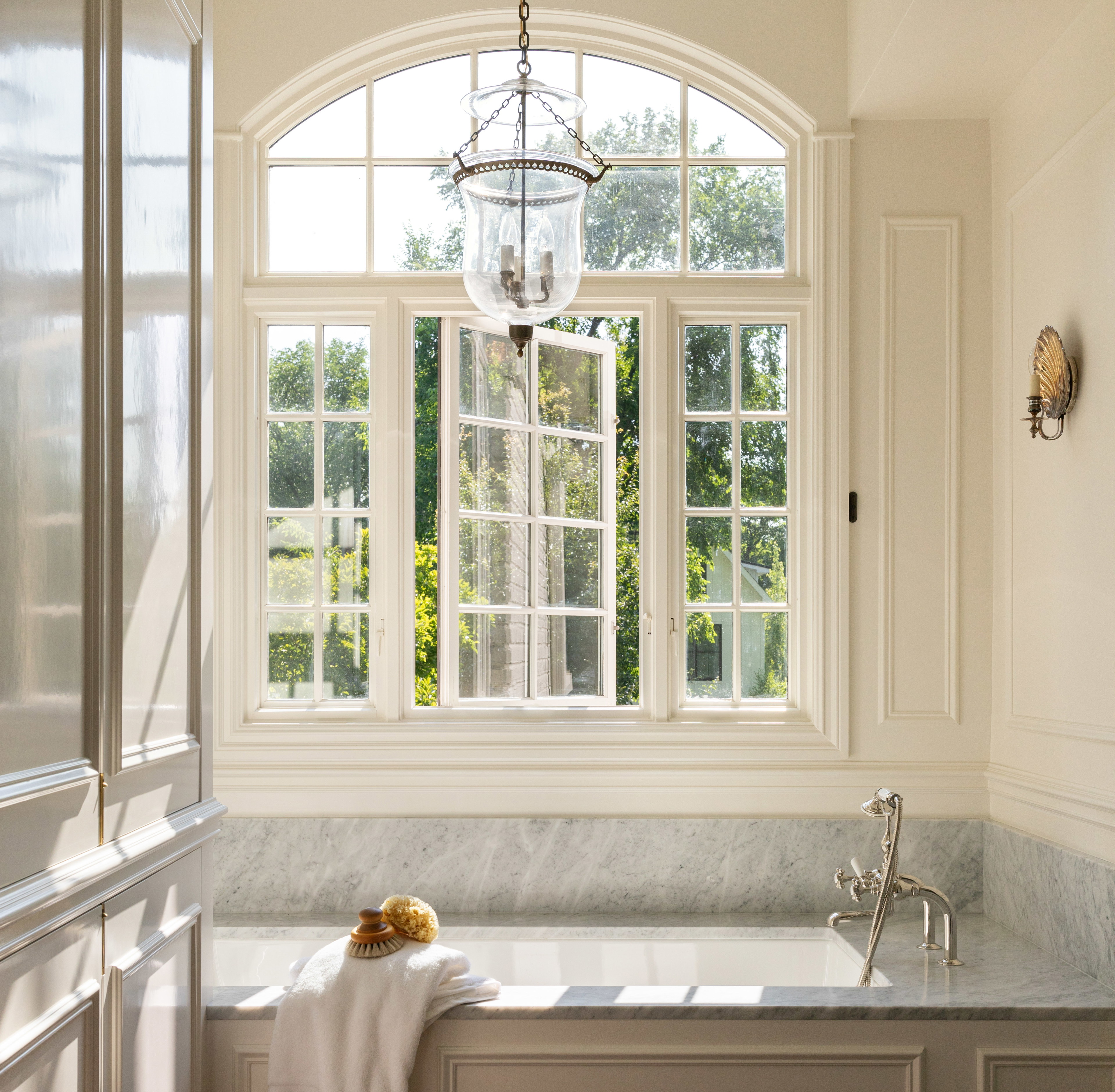 a bathroom with a tub and a chandelier