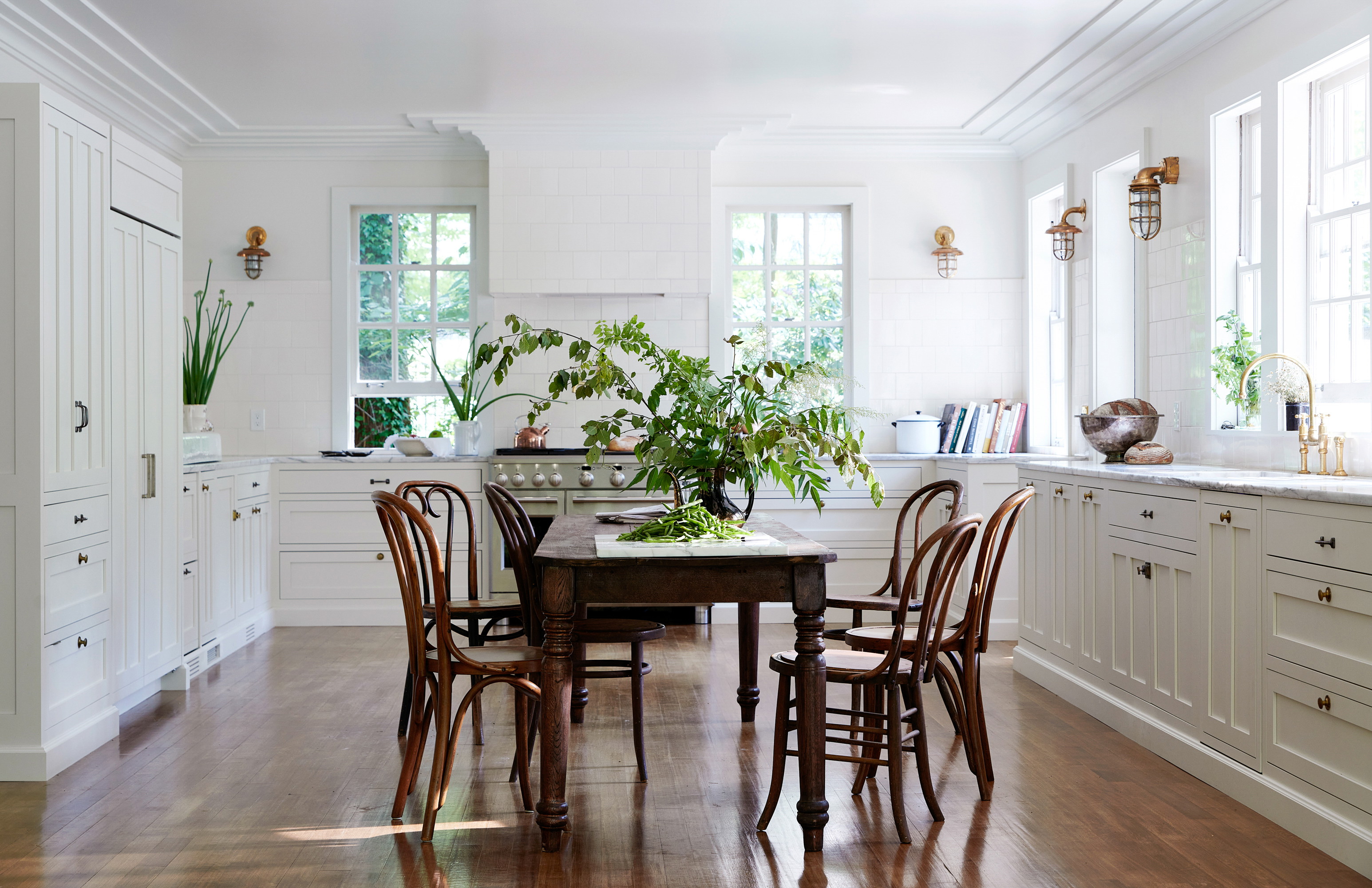 a kitchen with a table and chairs and a potted plant