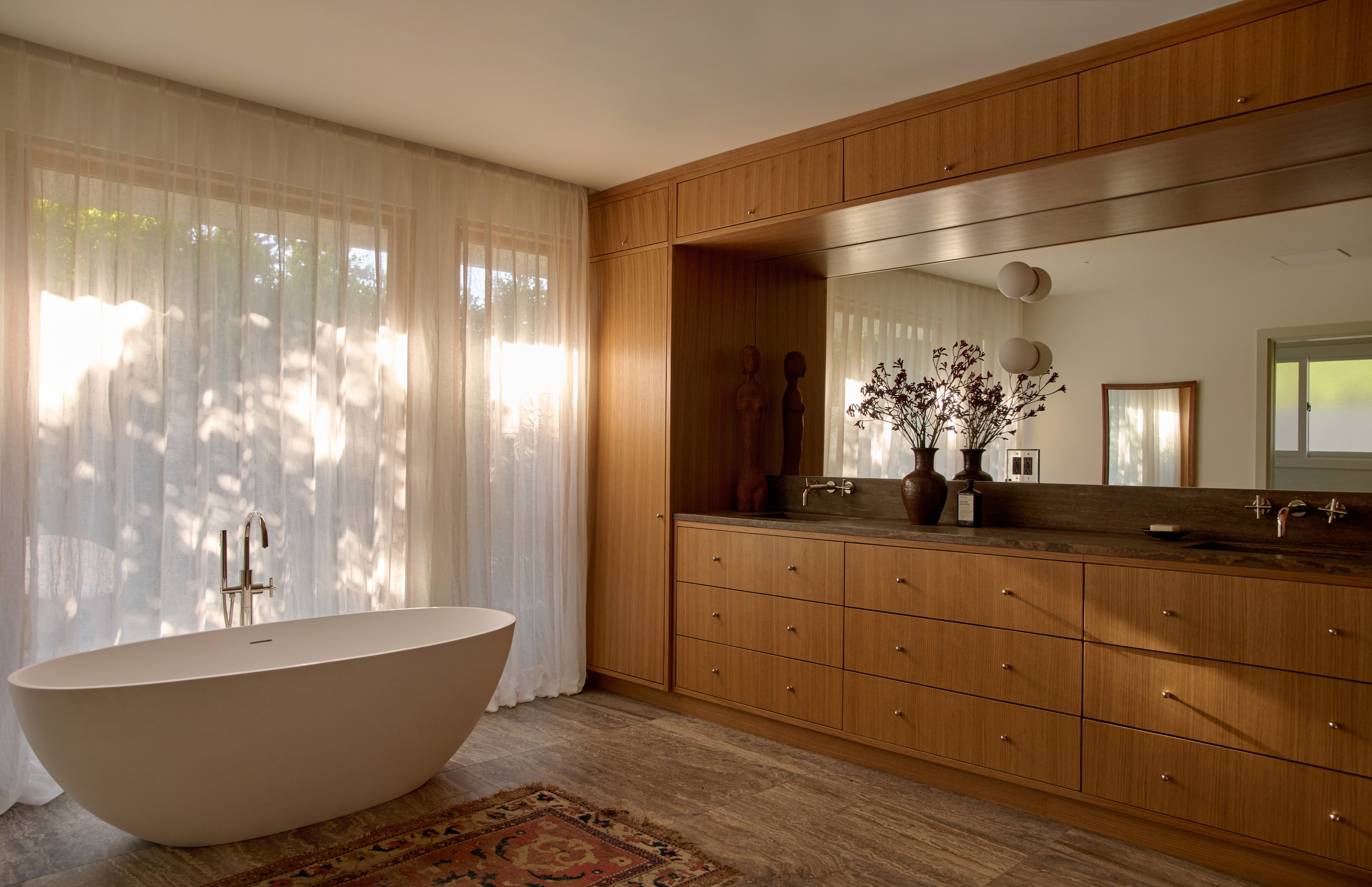 a bathroom with a tub and a large mirror