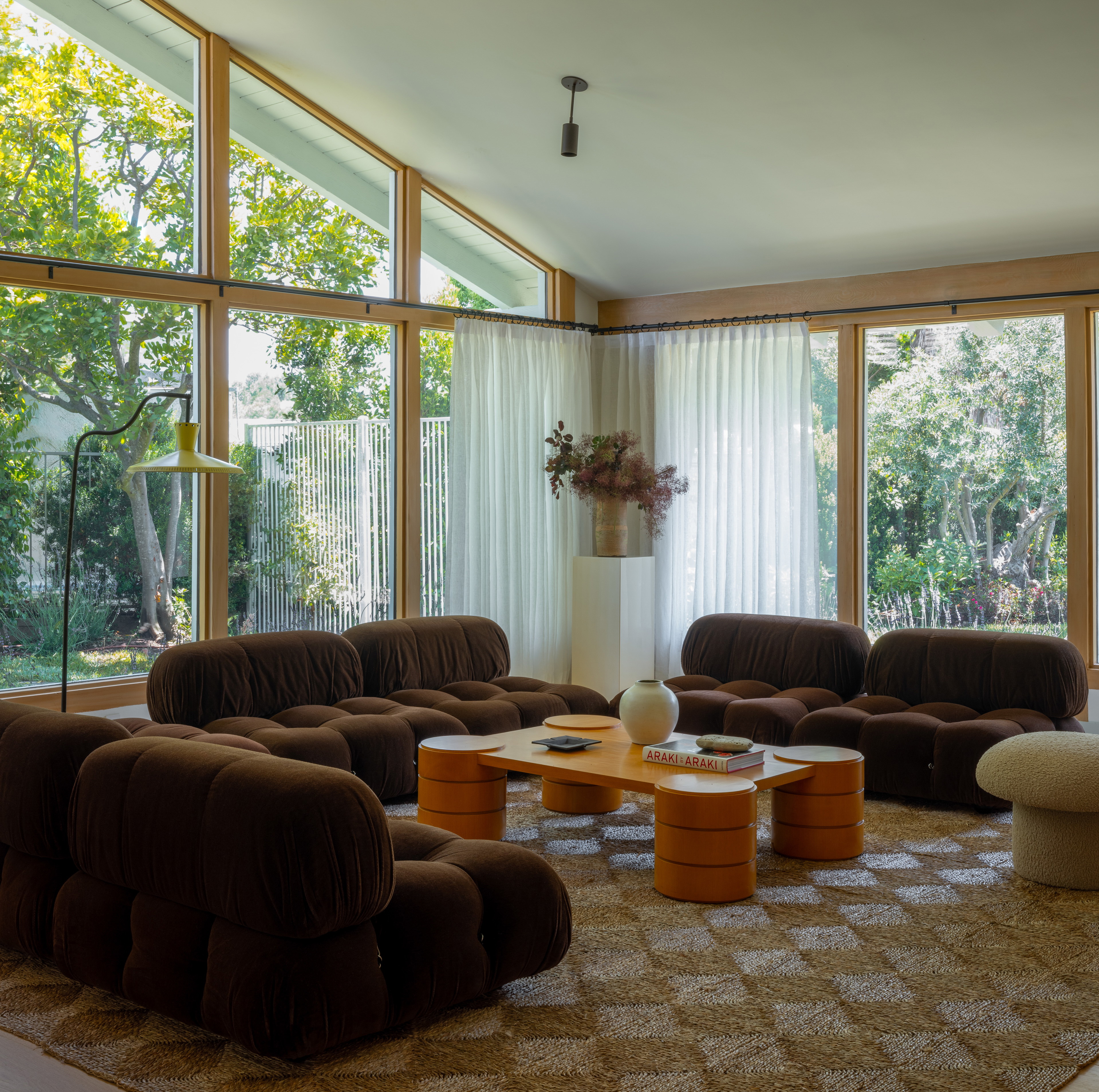 a living room filled with furniture and large windows