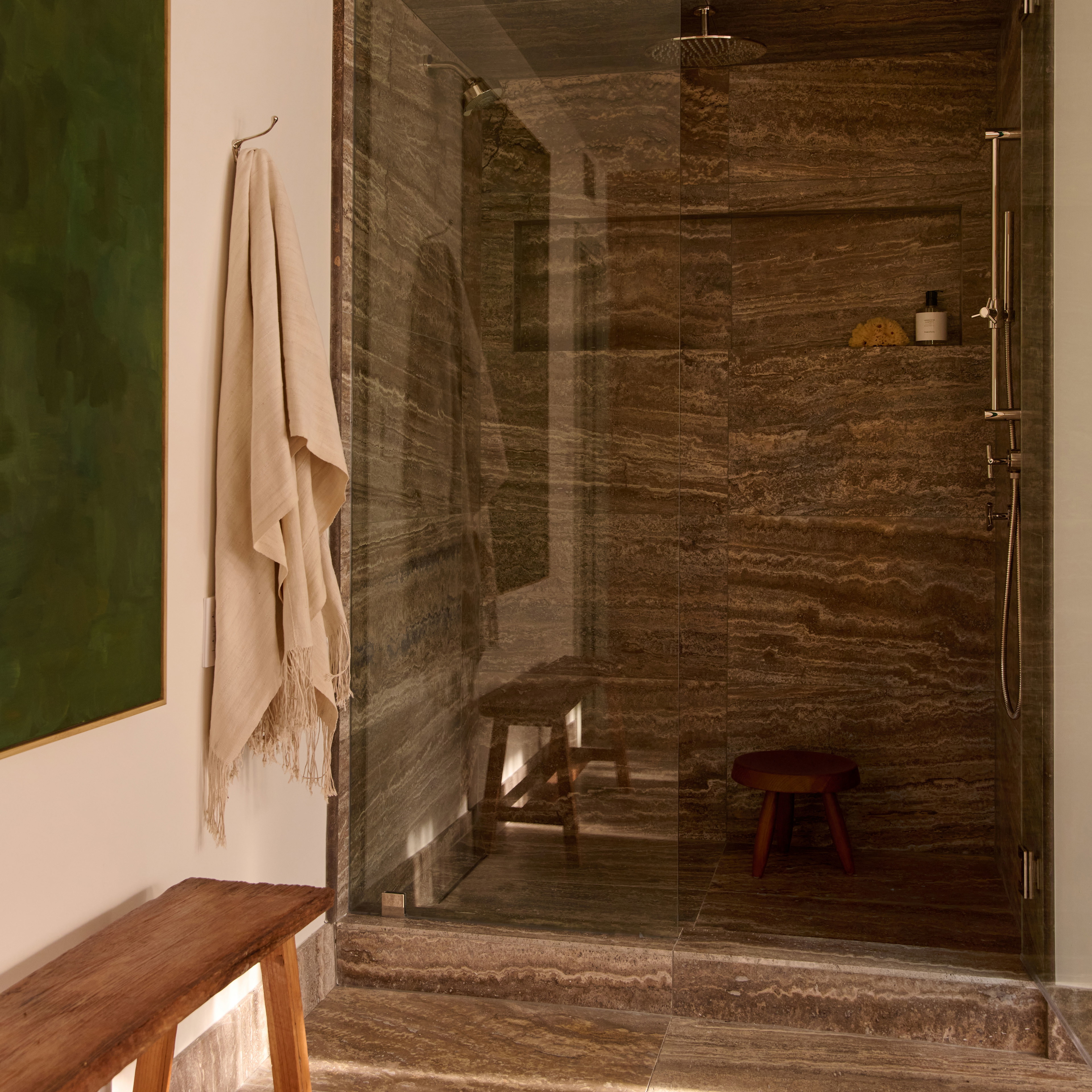 a bathroom with a walk in shower next to a wooden bench