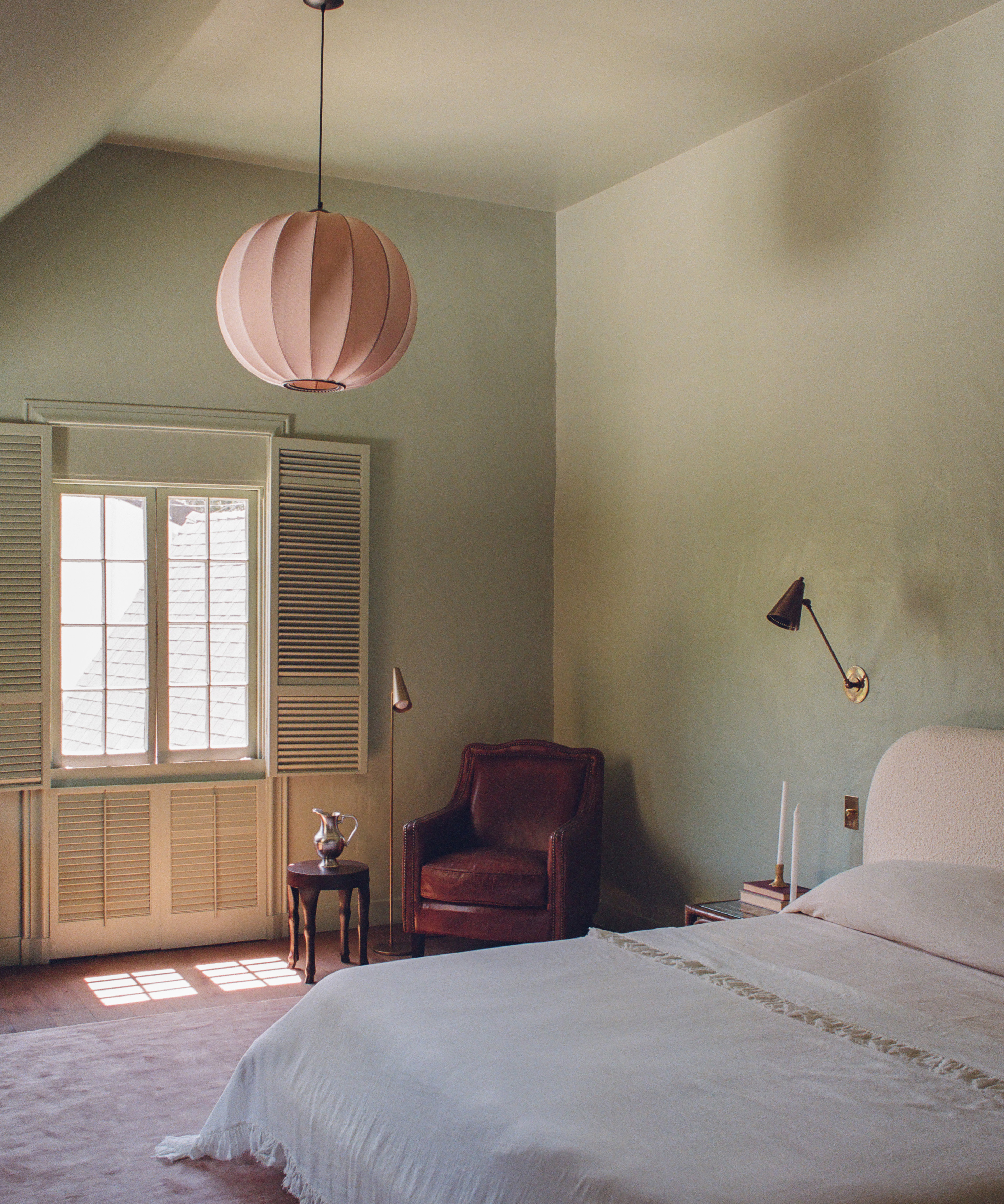 a bedroom with a white bed and a chair