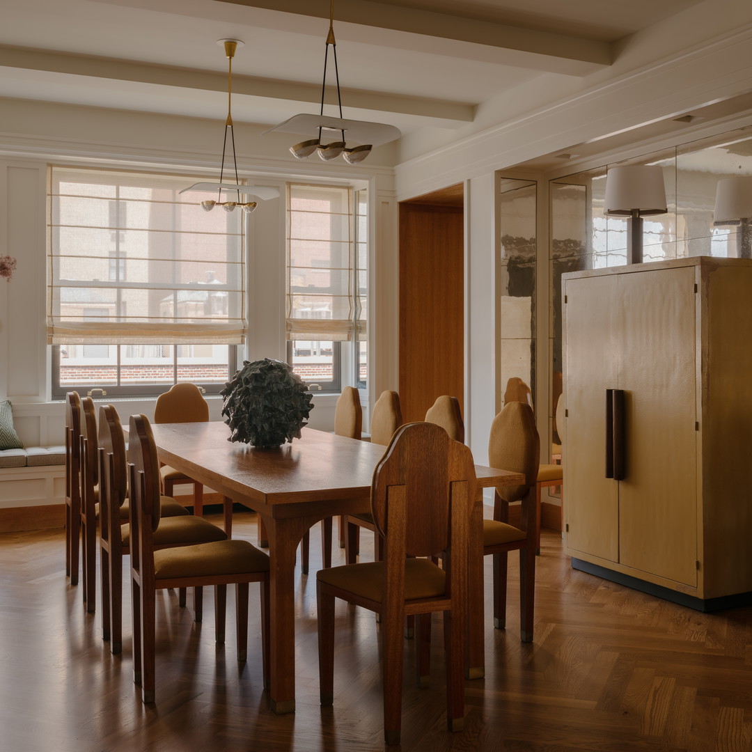 a dining room table with chairs and a refrigerator